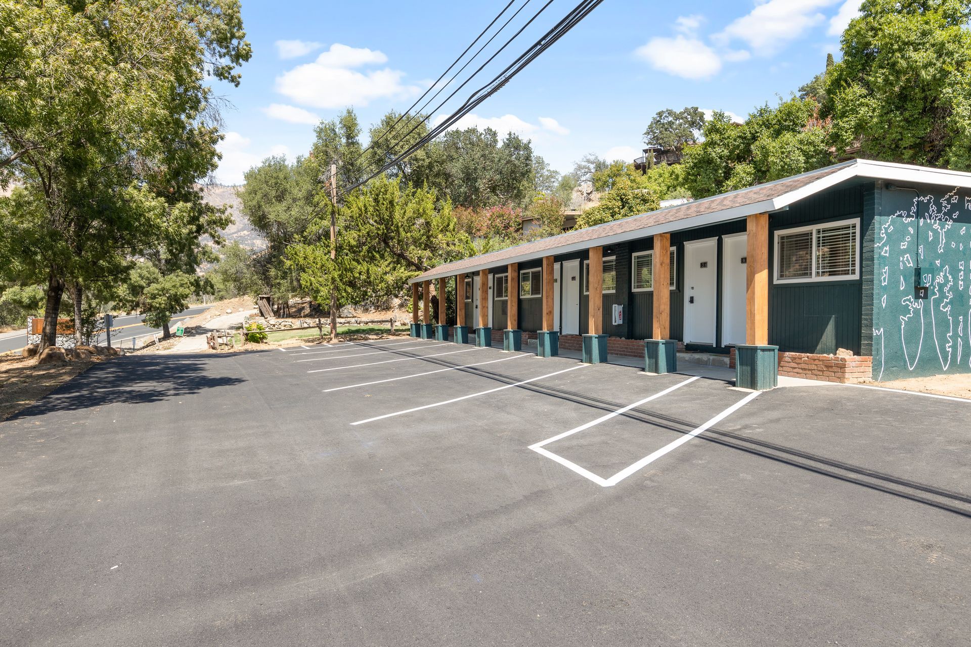 Exterior of a motel with parking spaces. Rooms 1-6.