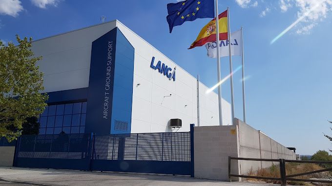 Un gran edificio blanco con banderas ondeando delante de él.