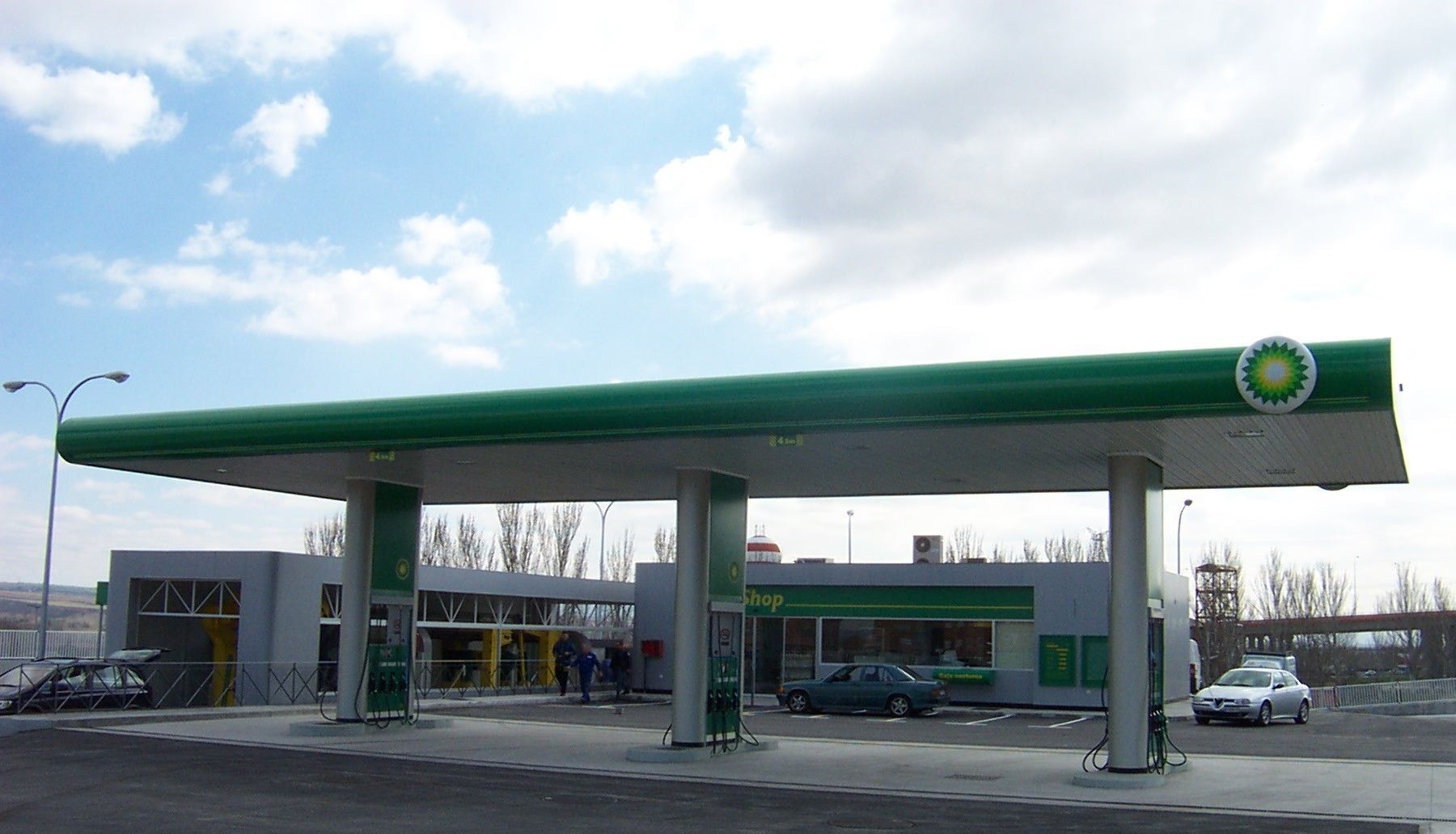 Una gasolinera BP con coches aparcados delante.