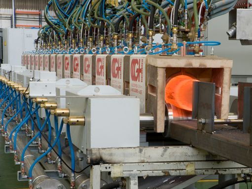 Una máquina está calentando una pieza de metal en una fábrica.
