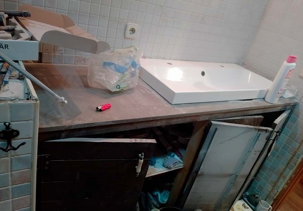 Un mostrador de baño con un lavabo y un encendedor encima.
