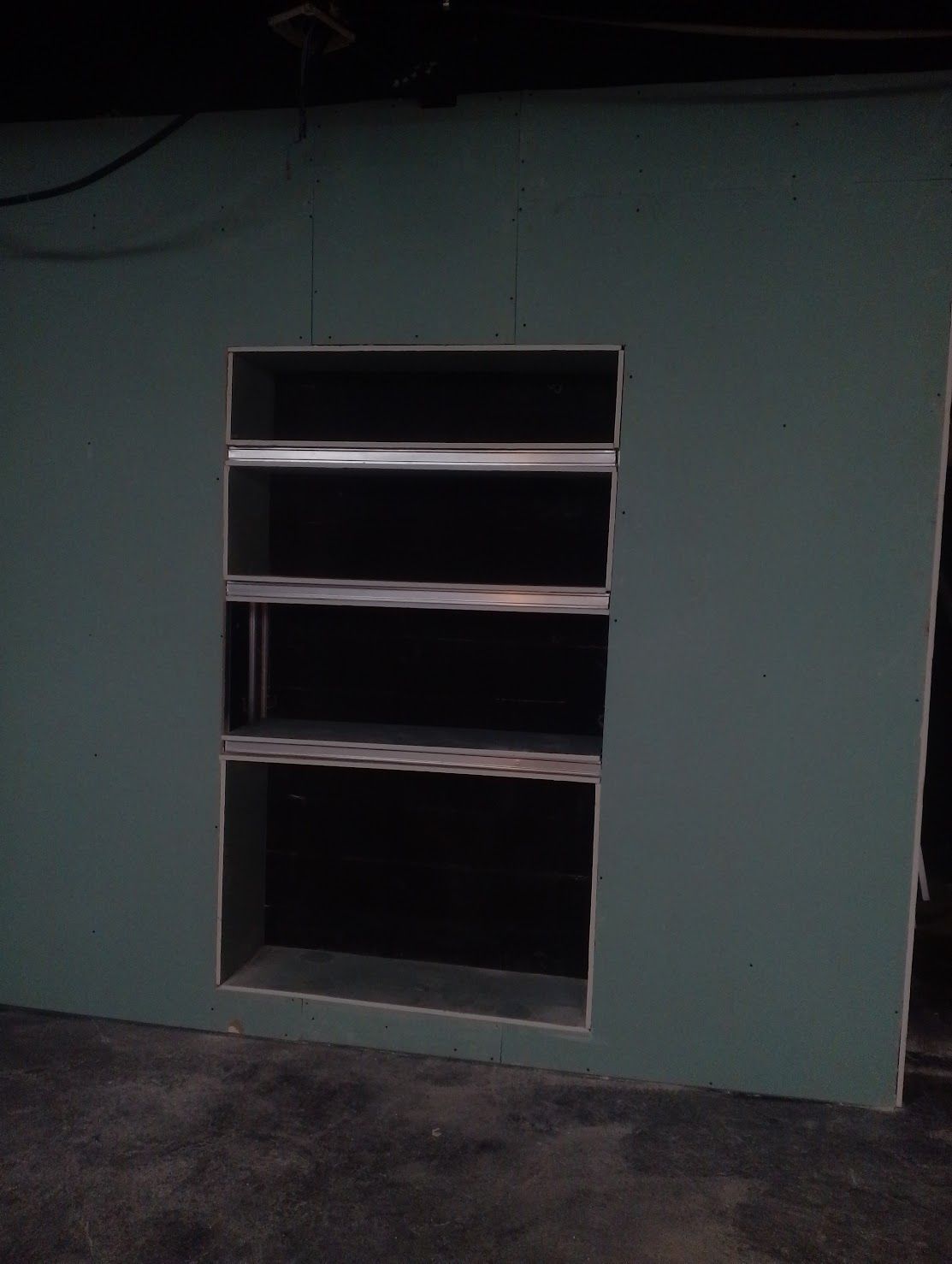 Una pared con una ventana y estantes.