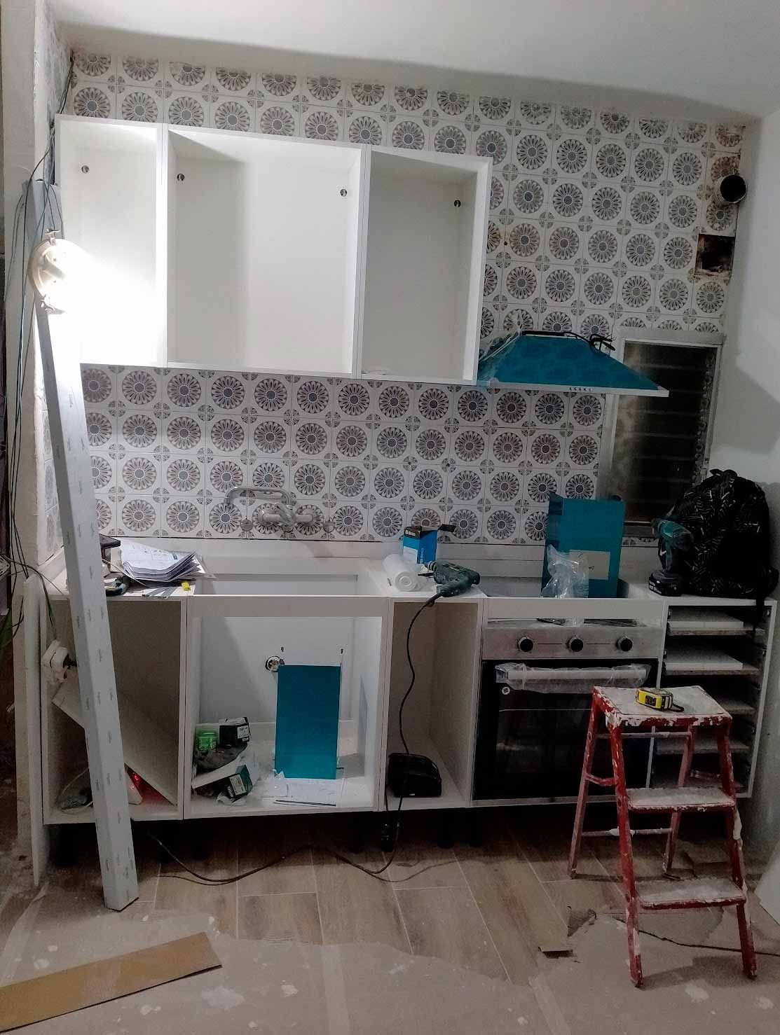 Una cocina en construcción con una escalera en el medio de la habitación.