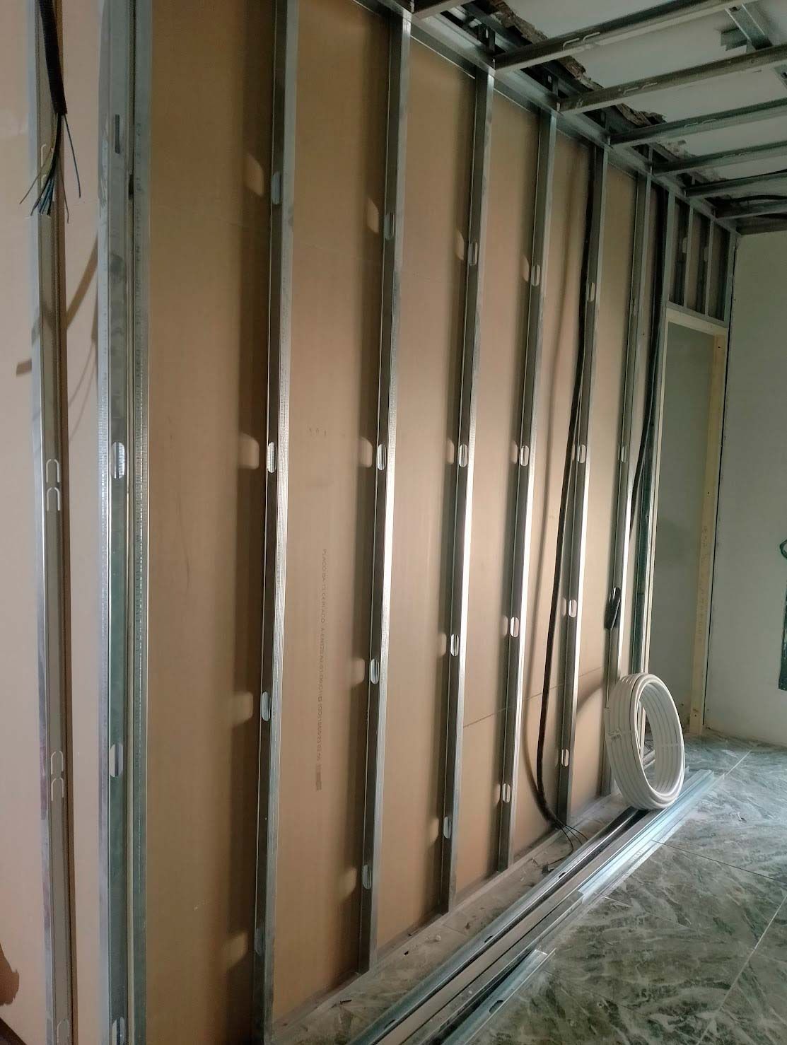 Una habitación con una pared que se está construyendo y una puerta.