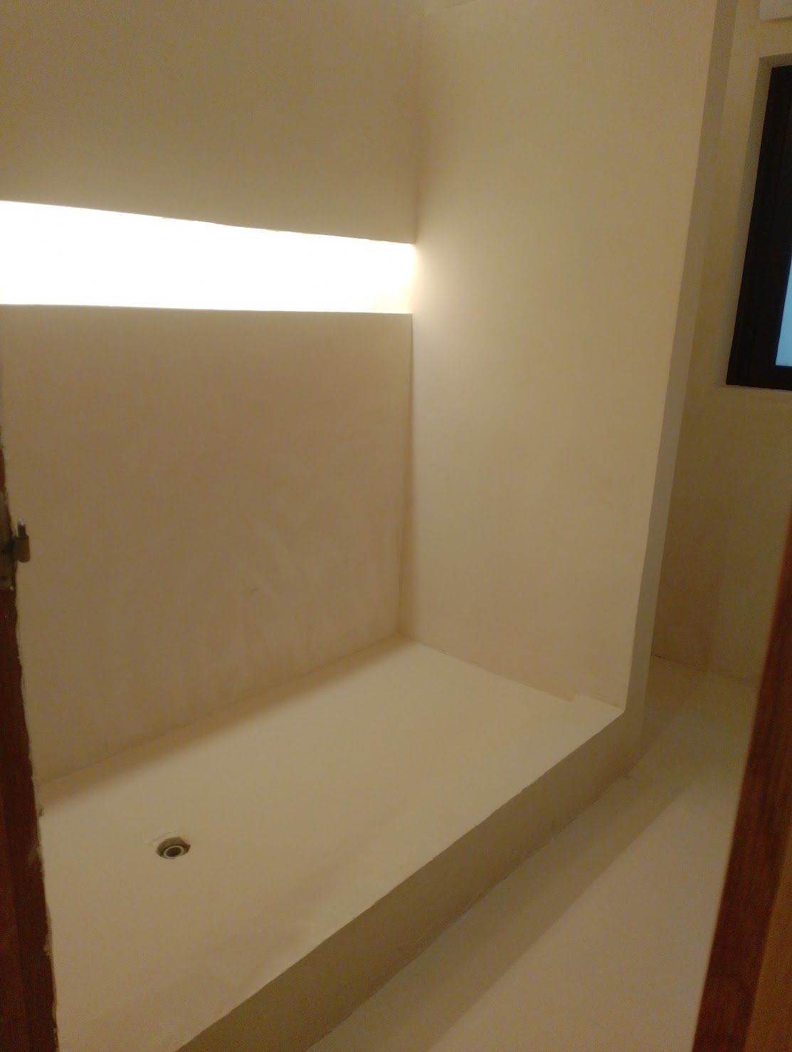 Un baño con ducha a ras de suelo y ventana.