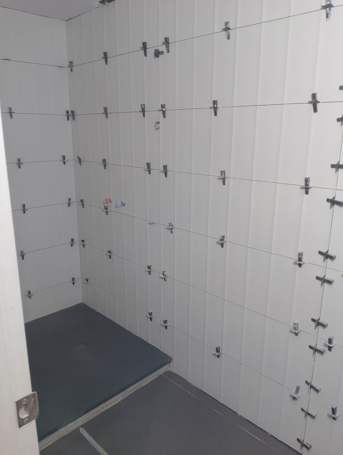 Un baño con azulejos blancos y cruces negras en la pared.