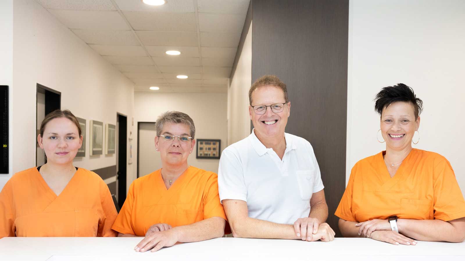 Eine Gruppe von Menschen in orangefarbenen Kitteln posiert für ein Foto