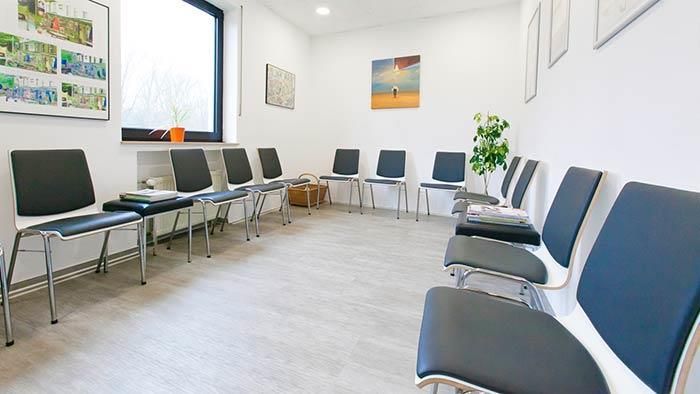 Ein Wartezimmer mit vielen Stühlen und einem Fenster