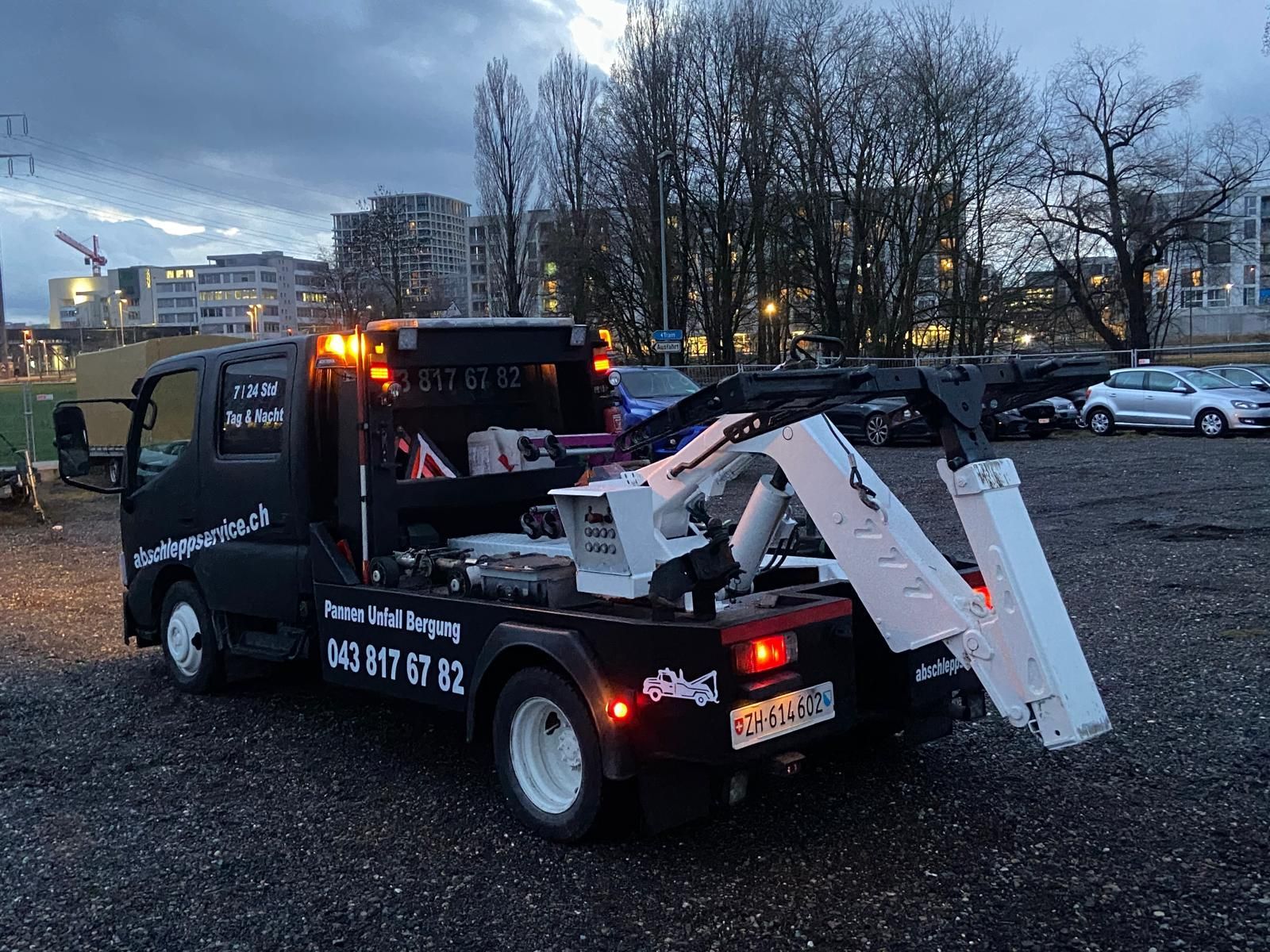Ein Strassenarbeiter in einer Warnweste schüttelt einem Mann vor einem Abschleppwagen die Hand.