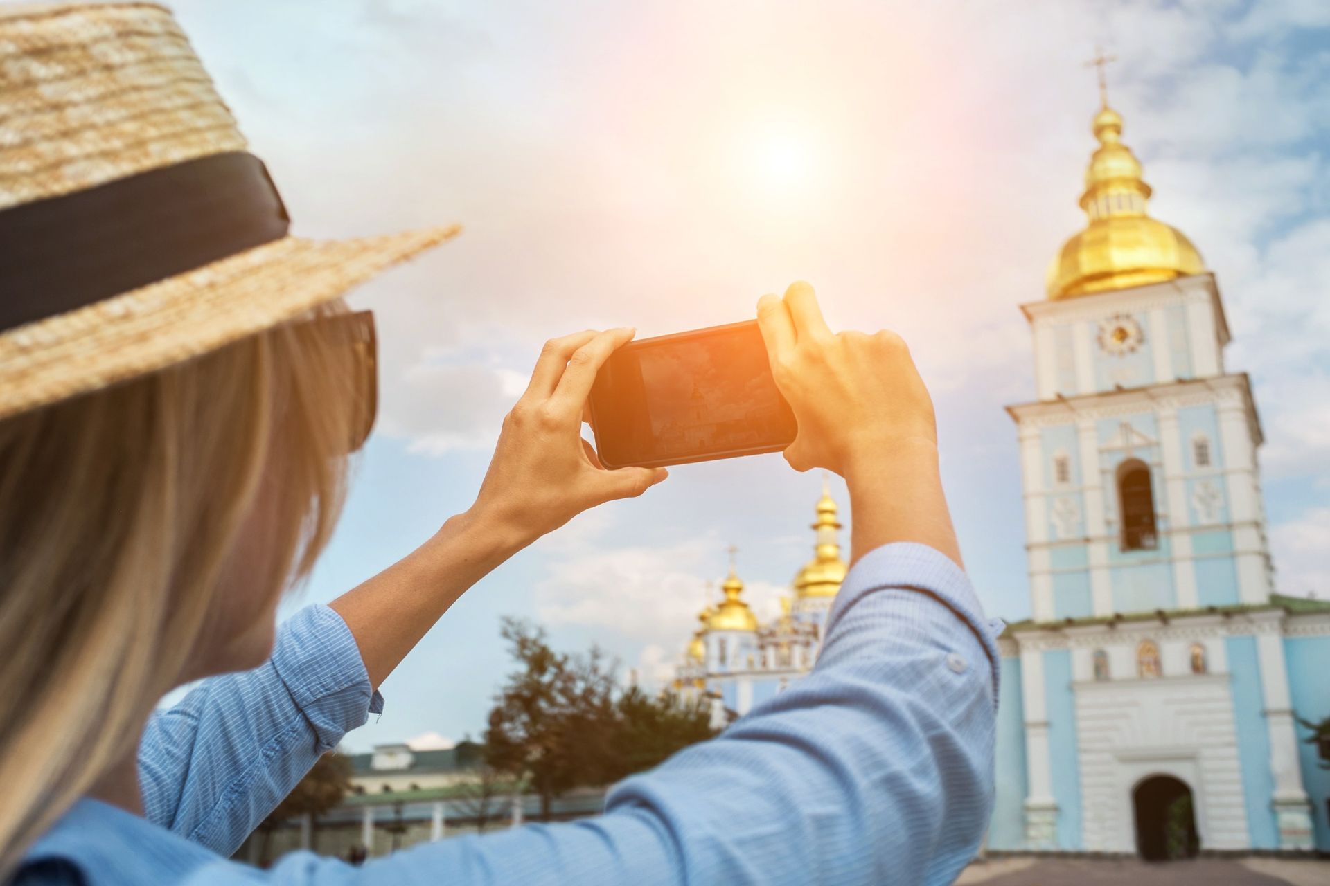 Una mujer está tomando una foto de una iglesia con su teléfono.