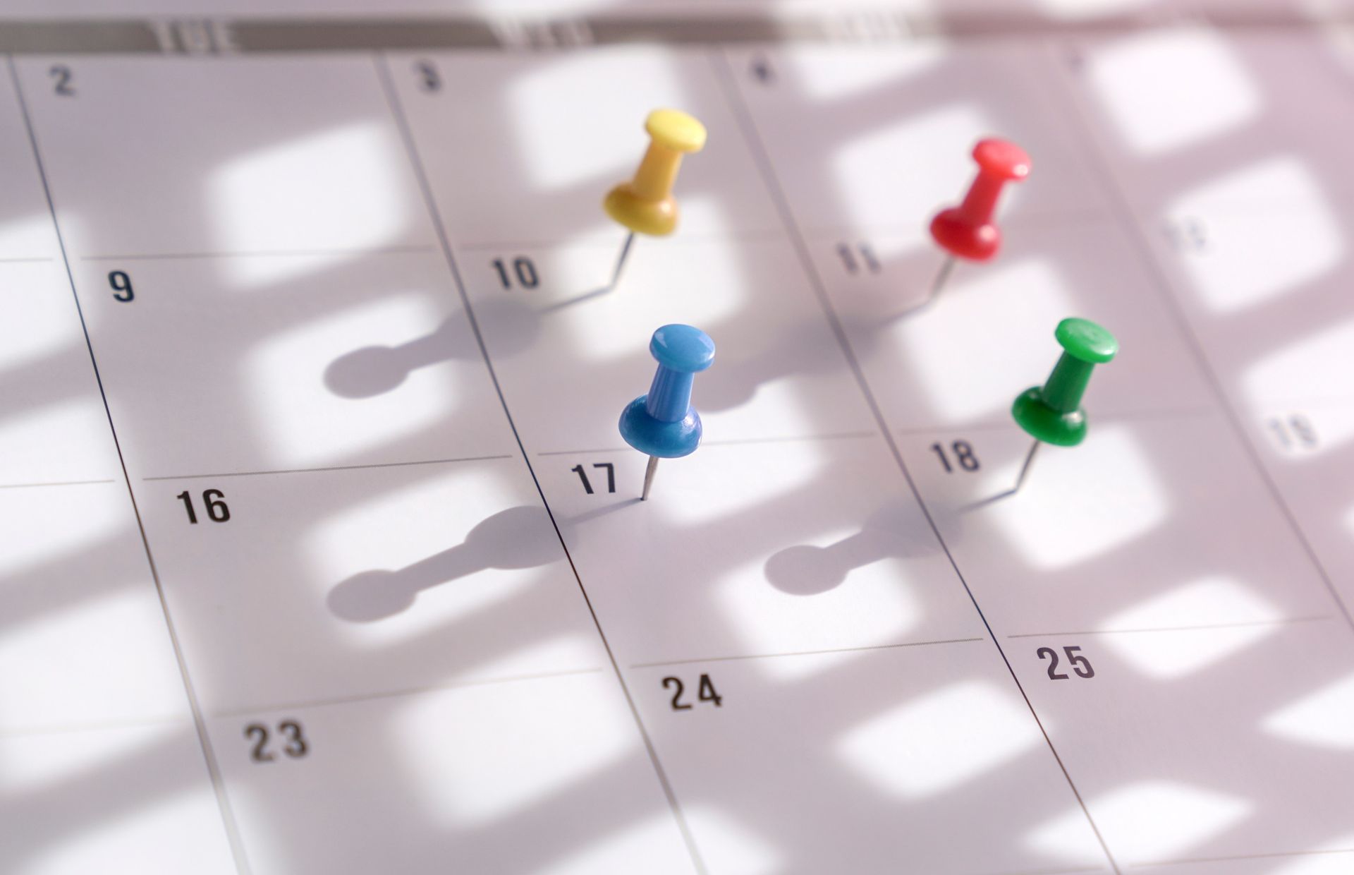Un calendario con tres alfileres clavados en él