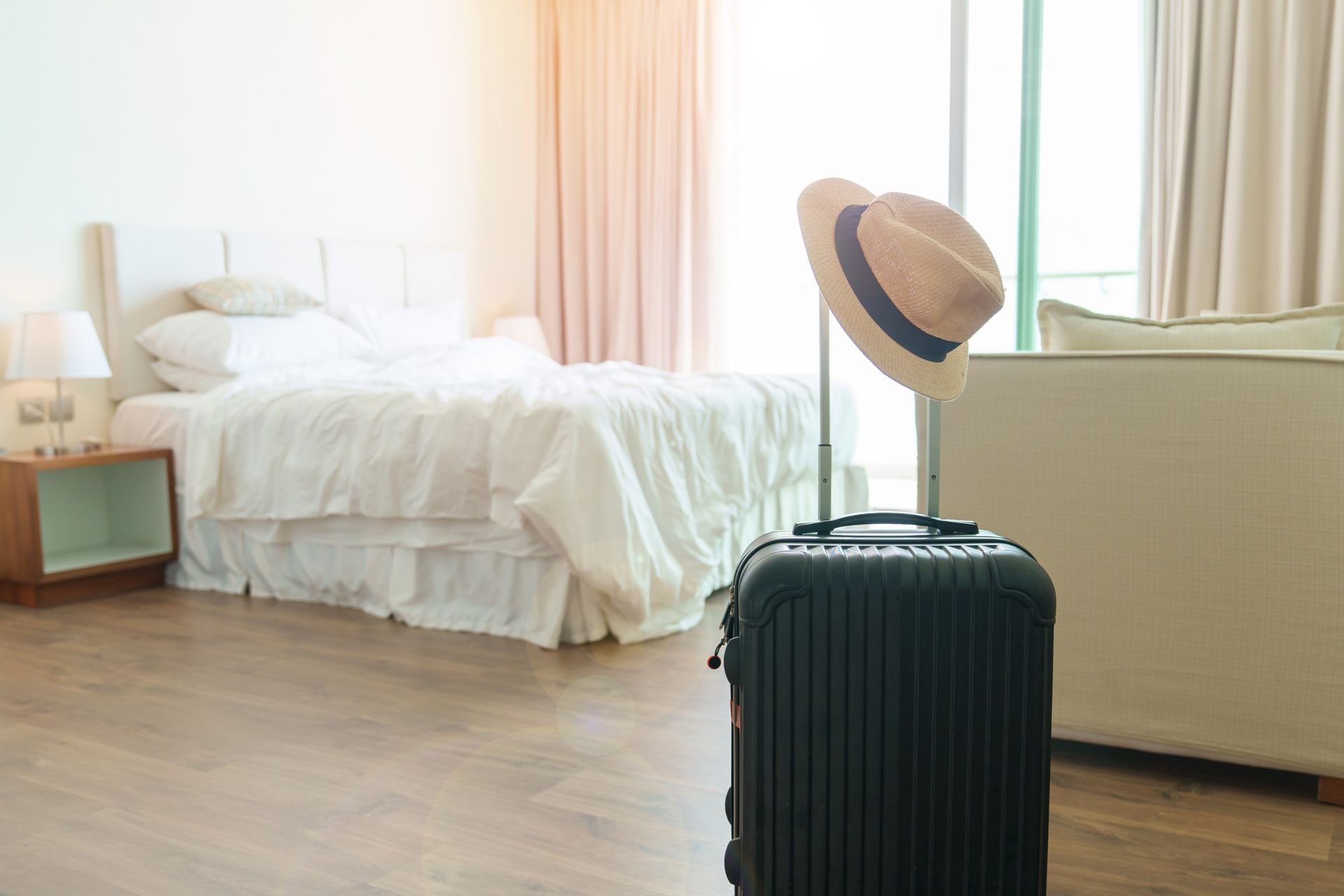 Una maleta con un sombrero colgando en una habitación de hotel.