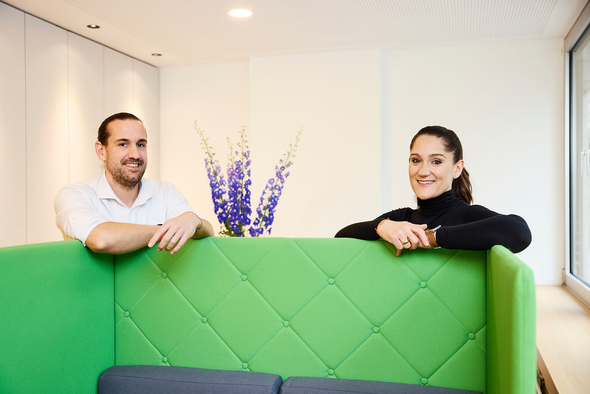 Ein Mann und eine Frau sitzen an einem Tisch und schauen auf ein Klemmbrett.