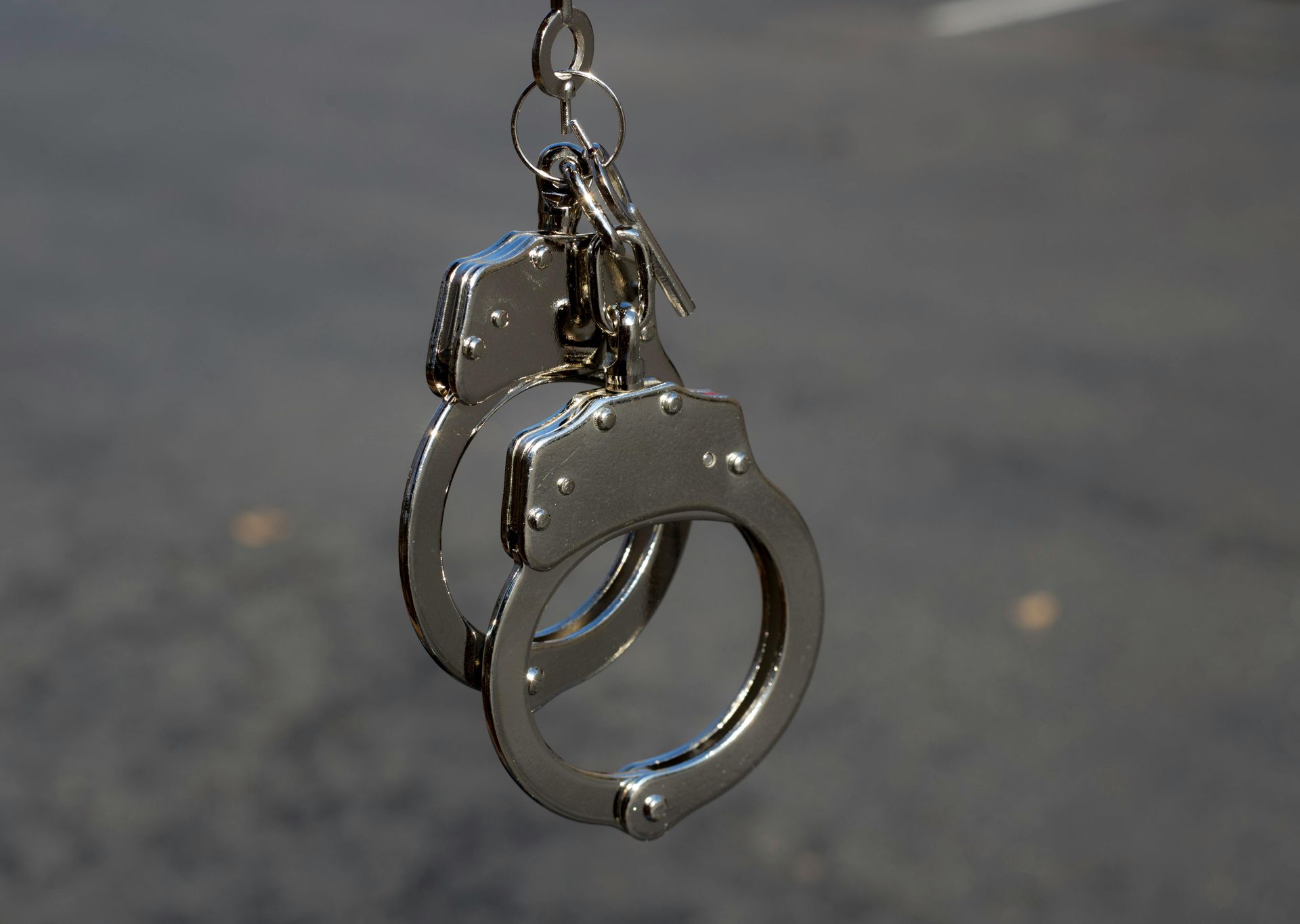 Ein Paar Handschellen mit Schlüsseln, die an einer Kette hängen