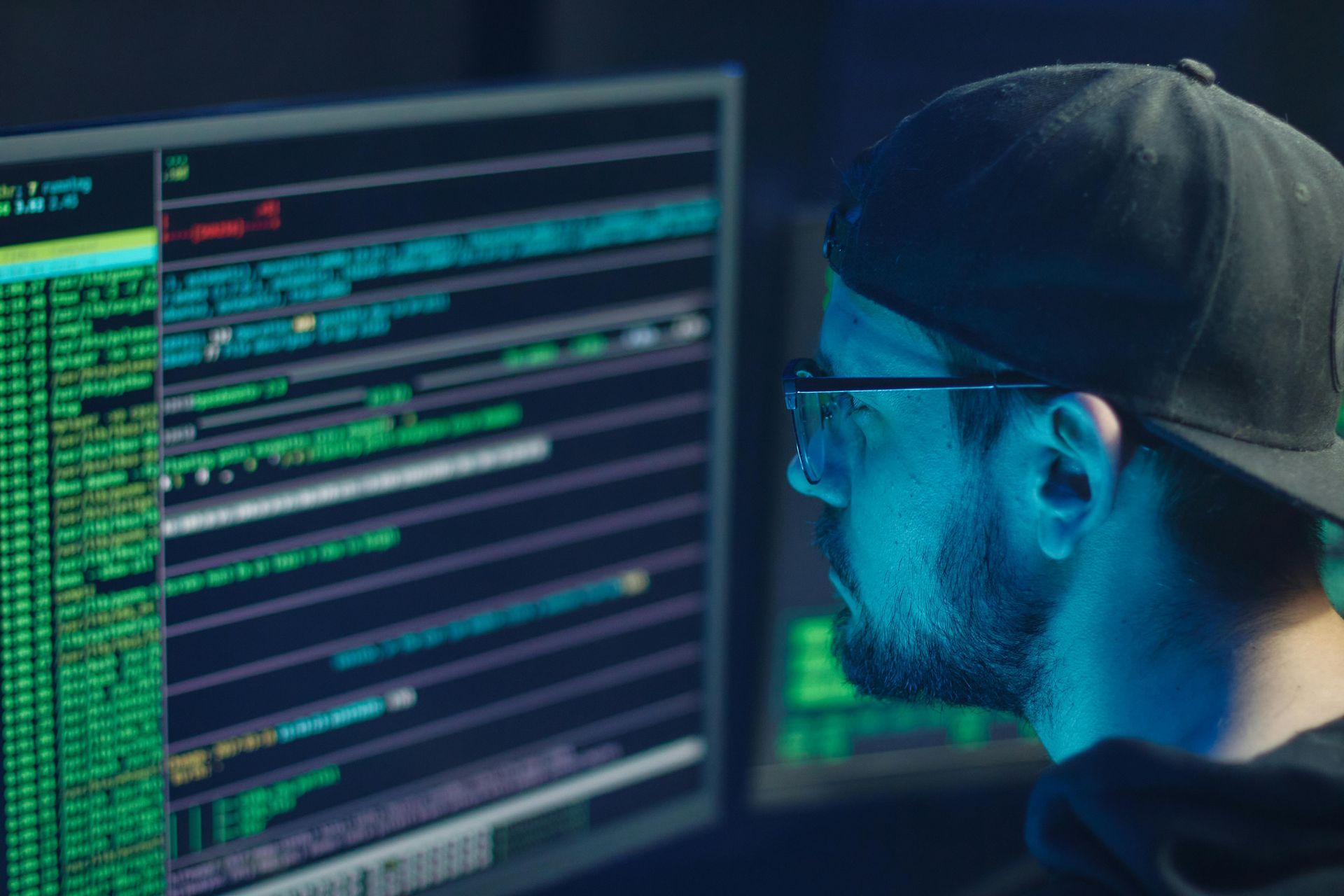 Ein Mann mit Hut und Brille schaut auf einen Computerbildschirm.