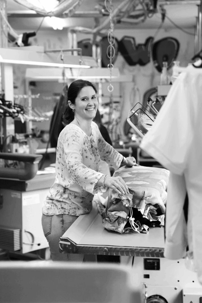 Frau vor gereinigten Kleidern und Hemden