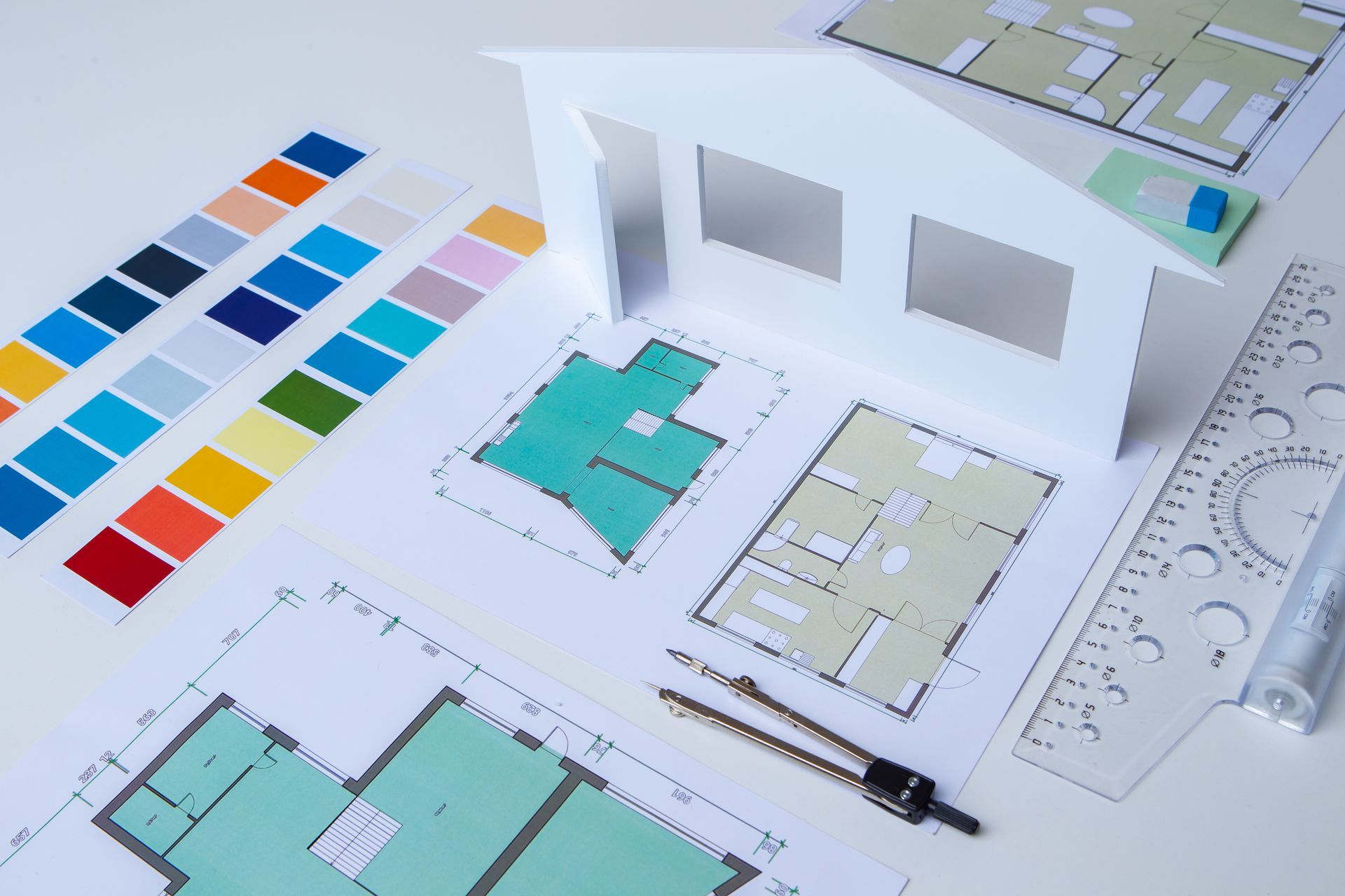 Plan posé sur une table avec des cartes de couleur et la maquette d'une façade