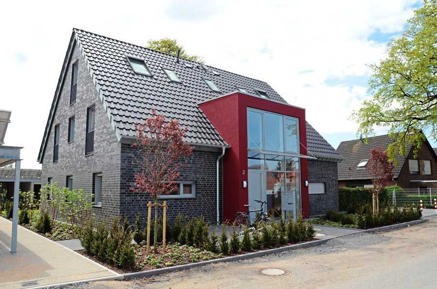 Ein Backsteinhaus mit roten Zierleisten und einem großen Fenster