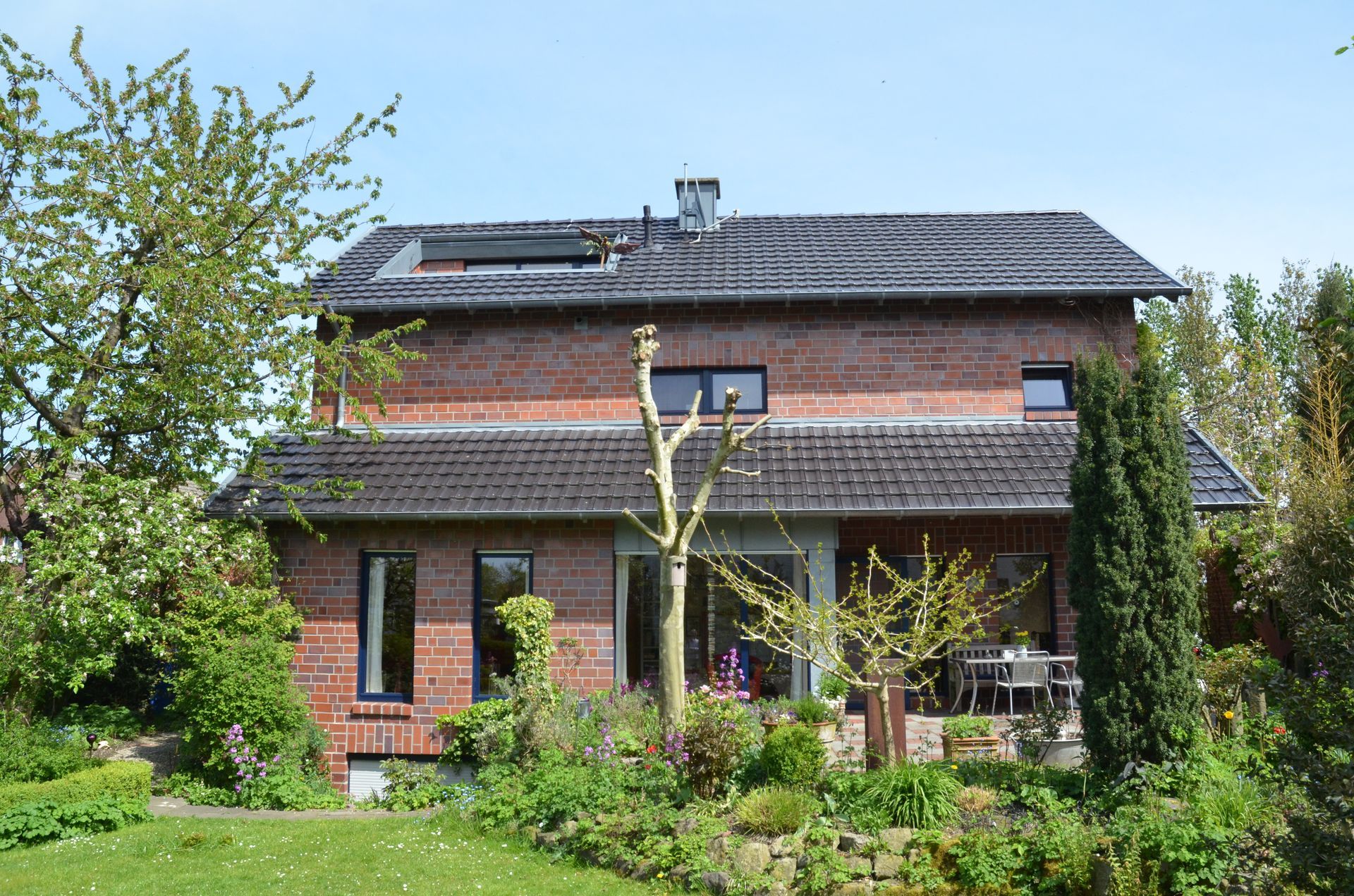Ein großes rotes Backsteinhaus mit einem schwarzen Dach