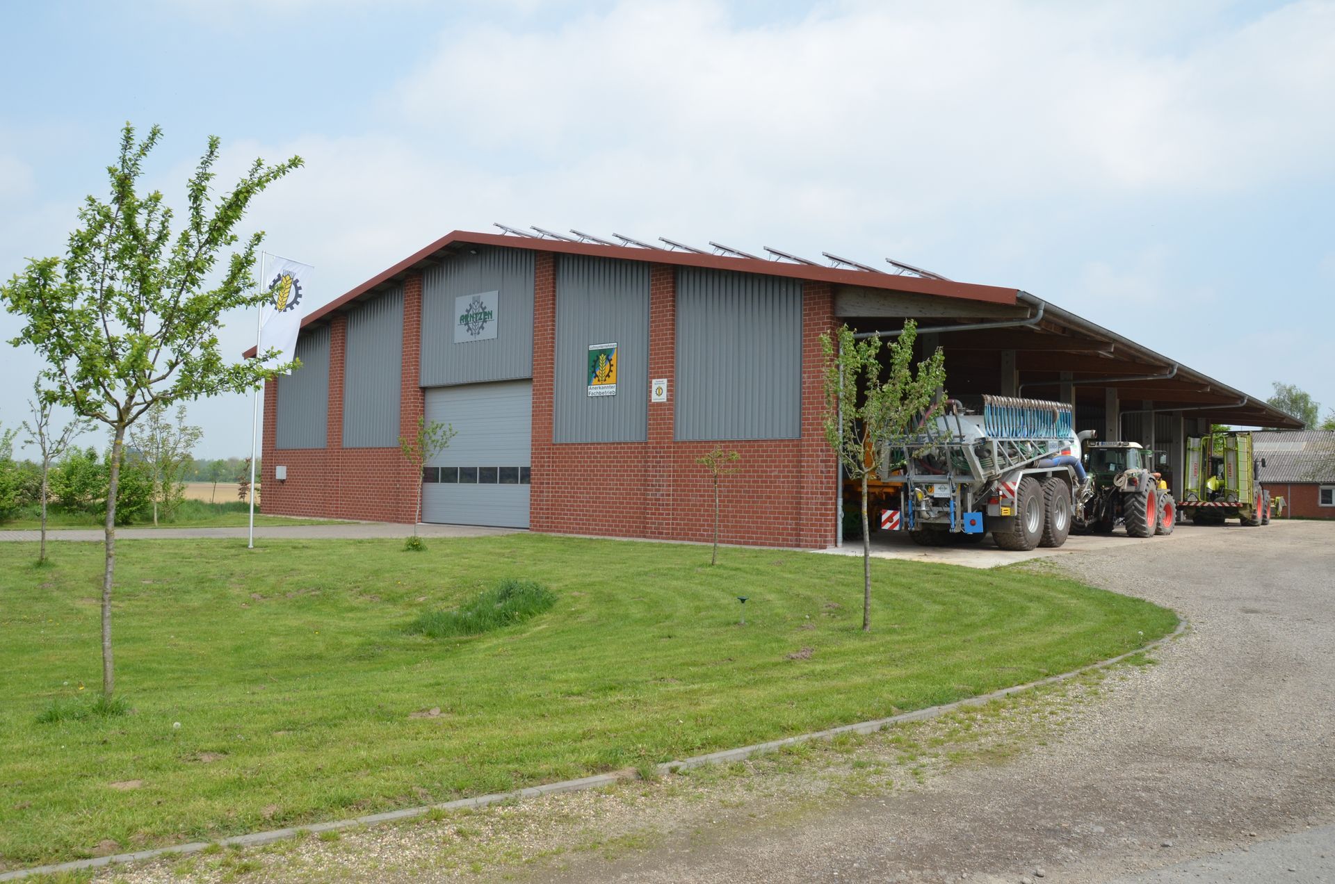 Ein großer Tierstall steht inmitten einer Wiese.