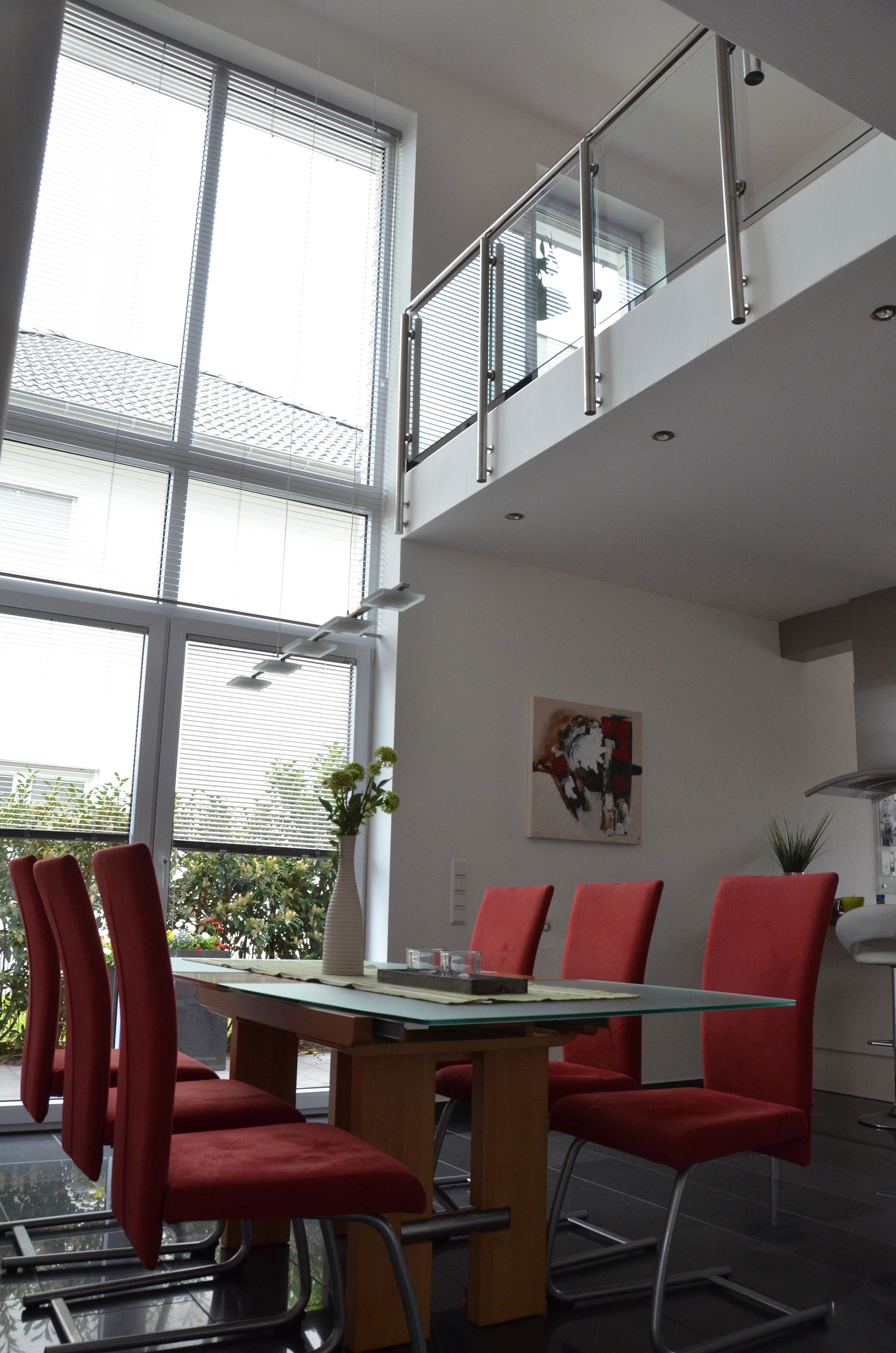 Ein Esszimmer mit Tisch und Stühlen und ein Balkon