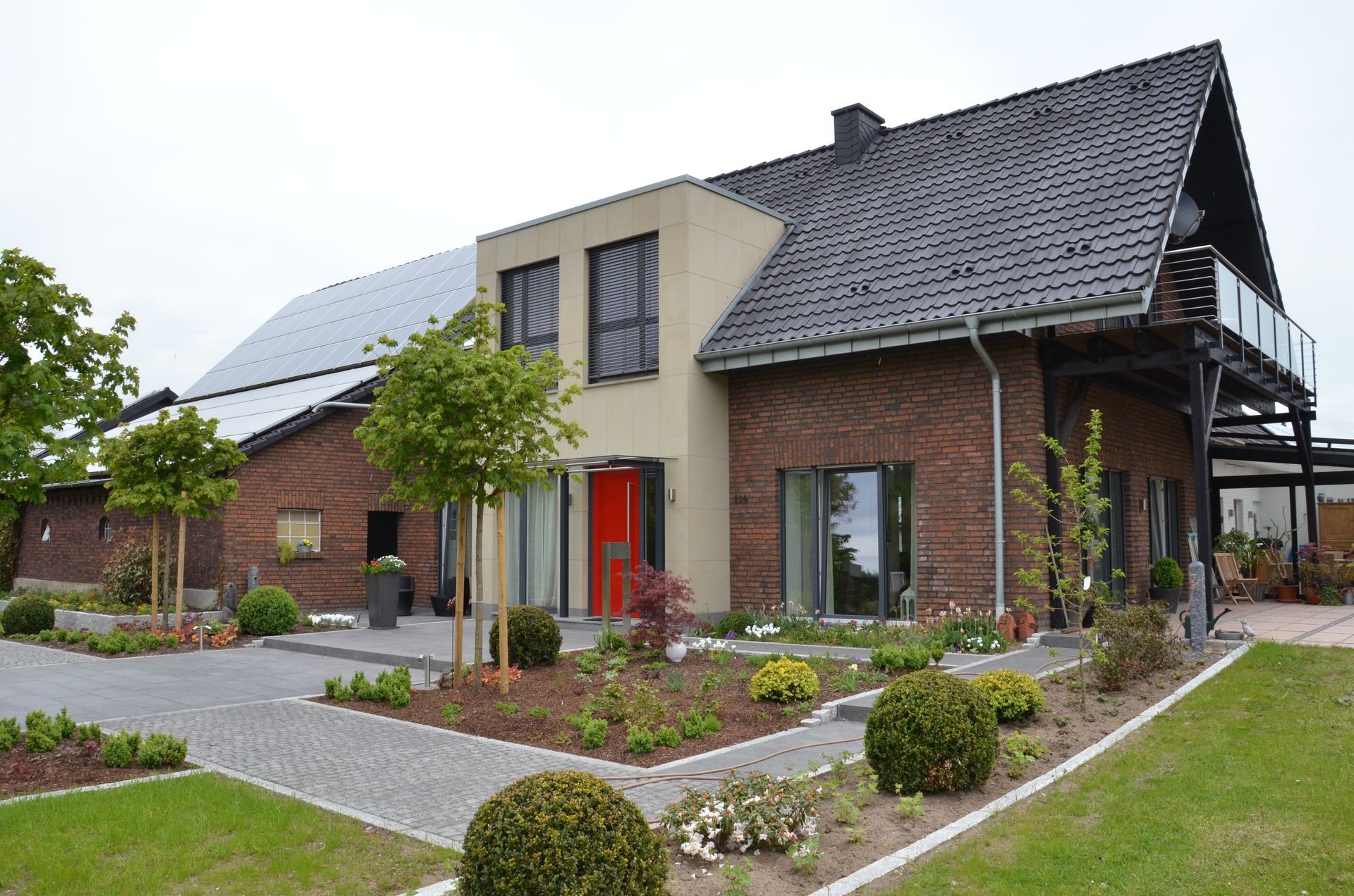Ein großes Haus mit einer roten Tür und Solarzellen auf dem Dach