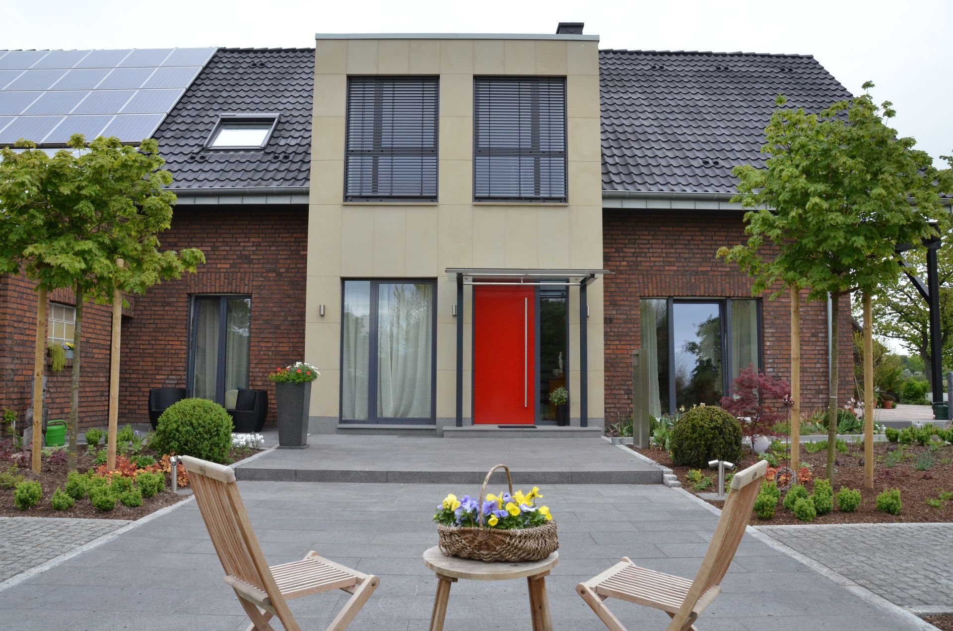 Ein Haus mit einer roten Tür und zwei Stühlen davor