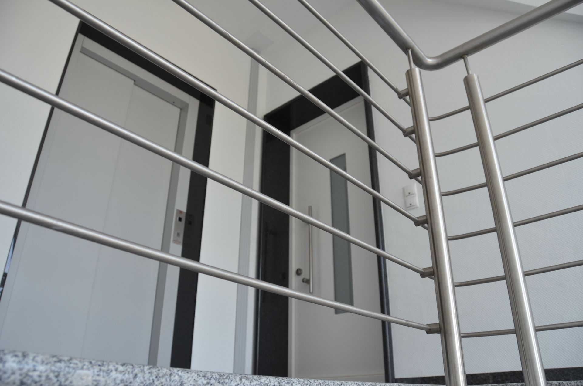 Eine Treppe mit Edelstahlgeländer und Tür