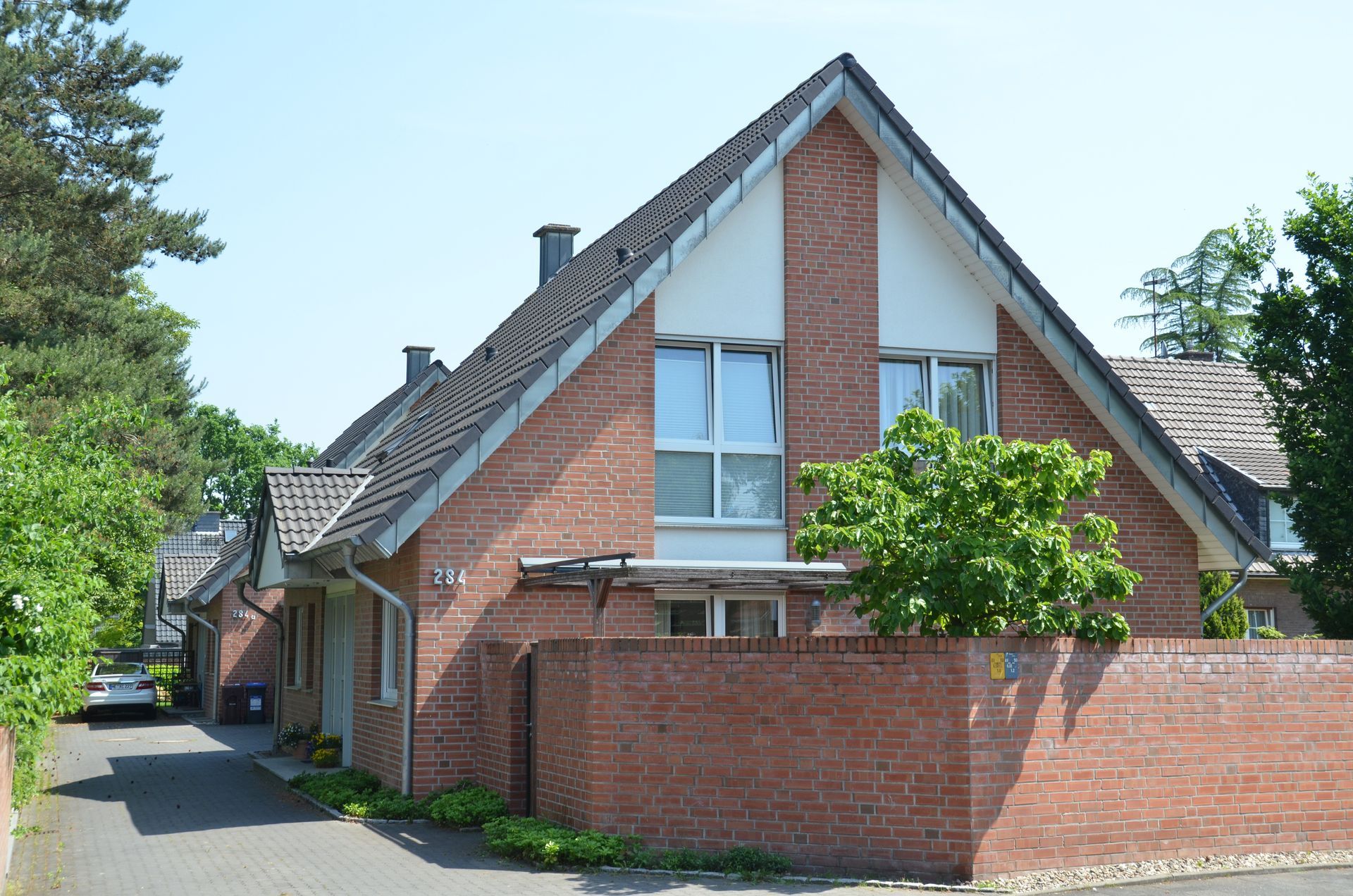 Ein Backsteinhaus mit einem davor geparkten Auto