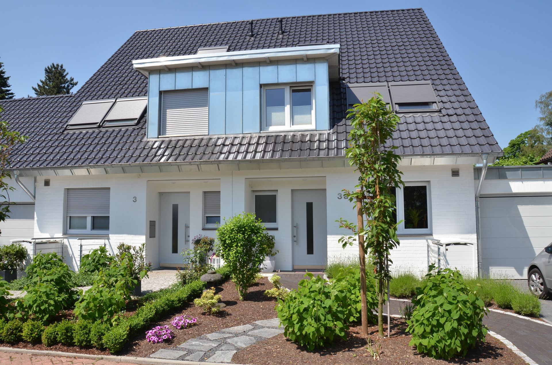 Ein großes weißes Haus mit einem schwarzen Dach