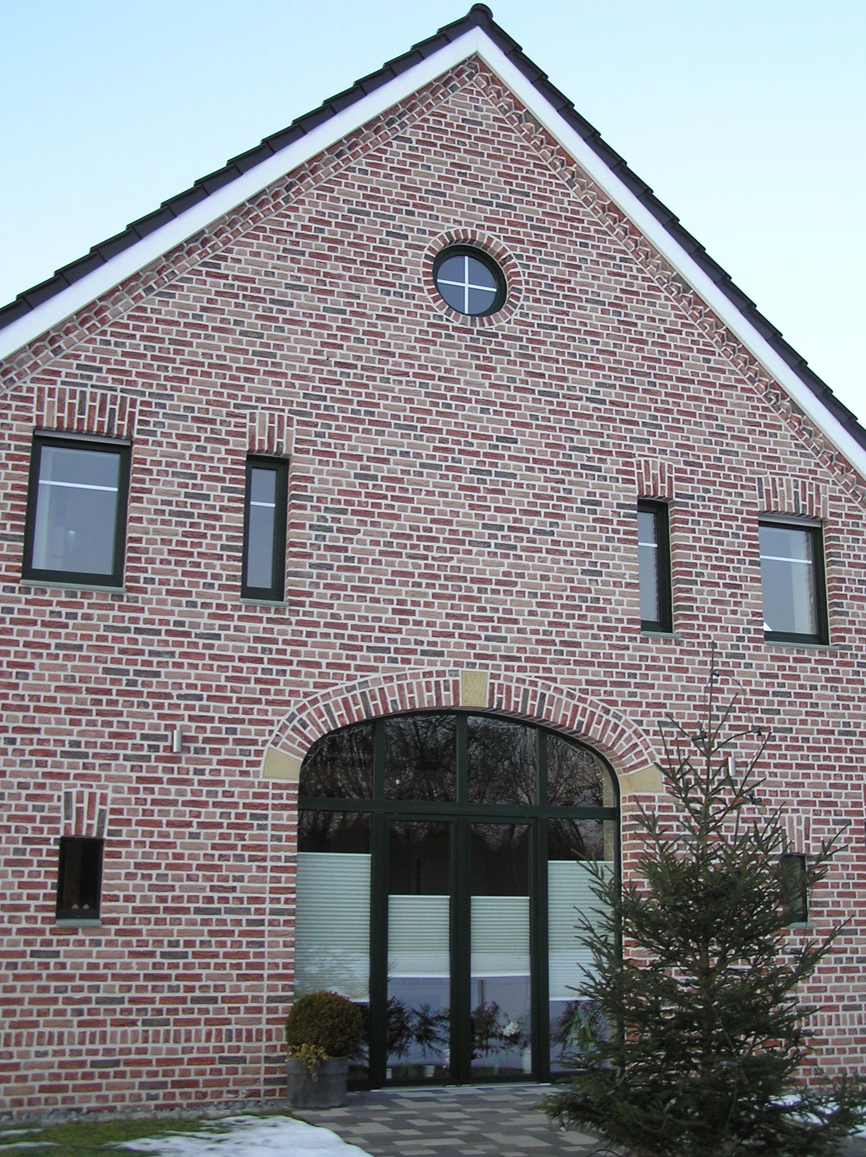 Ein Backsteingebäude mit einem runden Fenster auf dem Dach