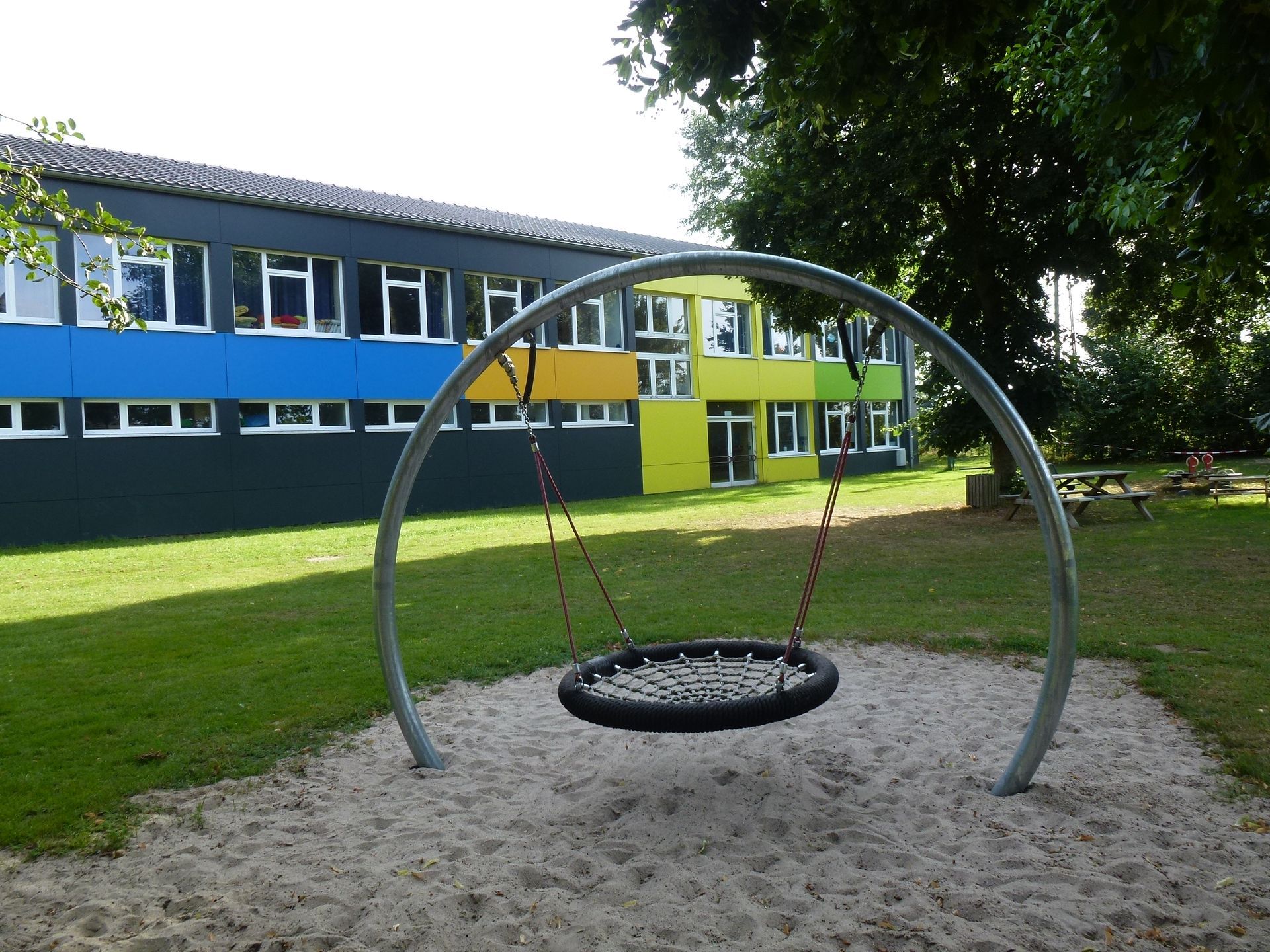 Ein Spielplatz mit einer Schaukel vor einem Gebäude