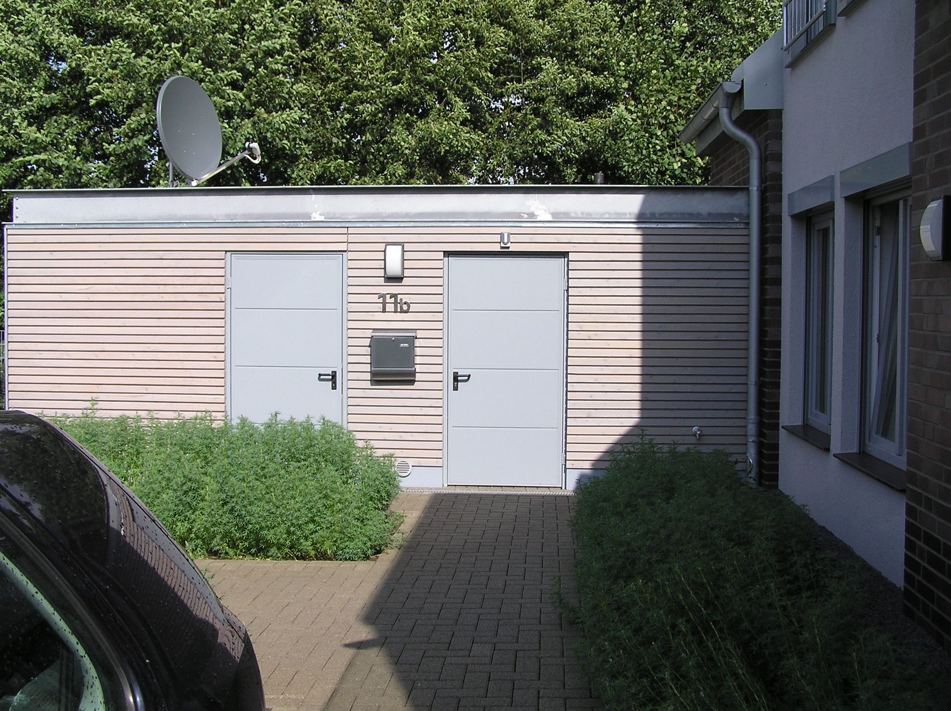 Vor einem modernen Gebäude steht ein Auto