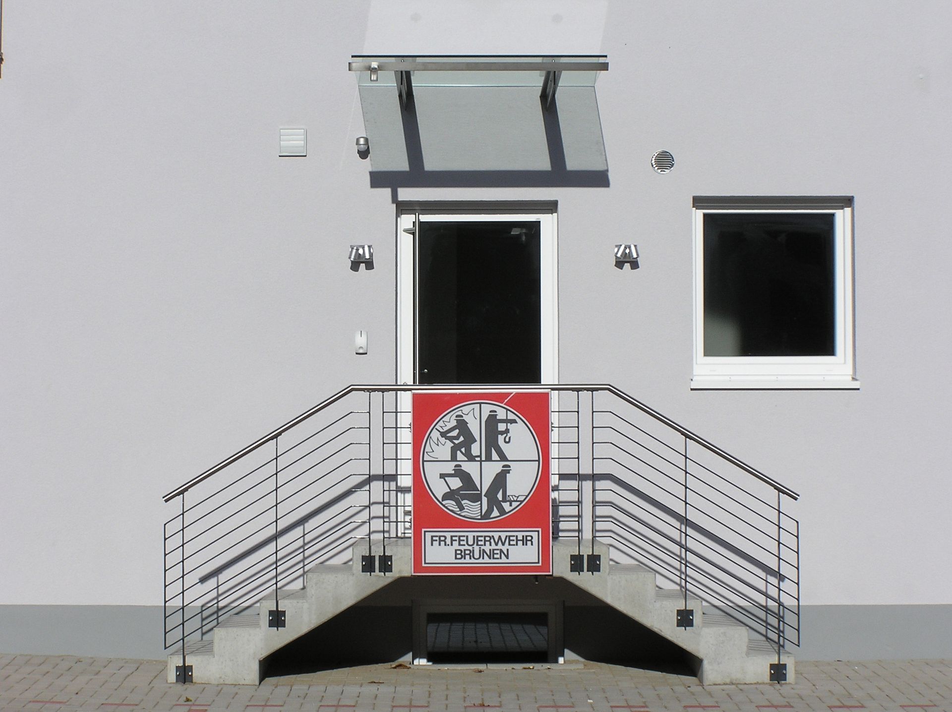 Ein weißes Gebäude mit Treppen, die zur Tür der Feuerwache hinaufführen