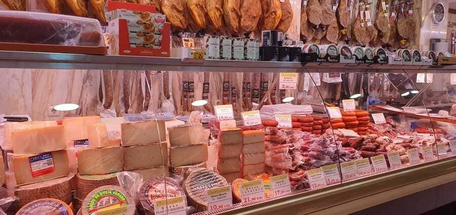 Una vitrina llena de una variedad de quesos y carnes.