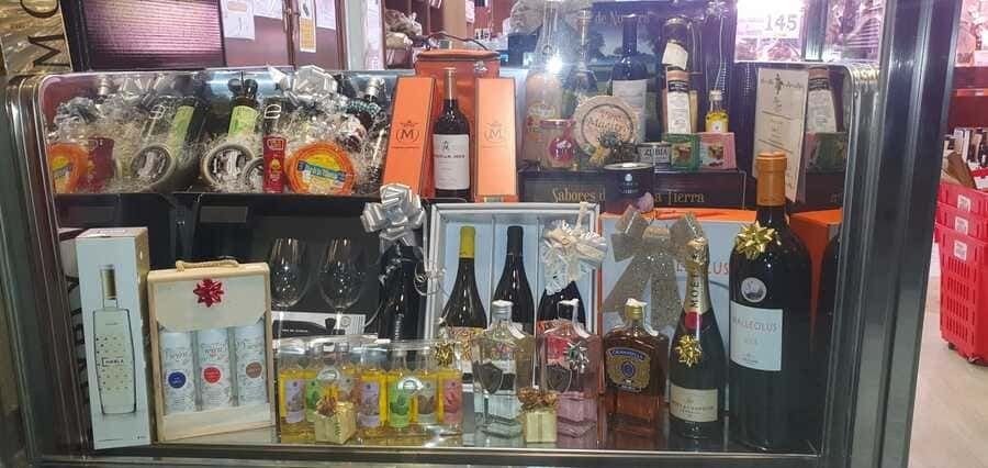 Una vitrina de cristal llena de botellas de vino y otros artículos.