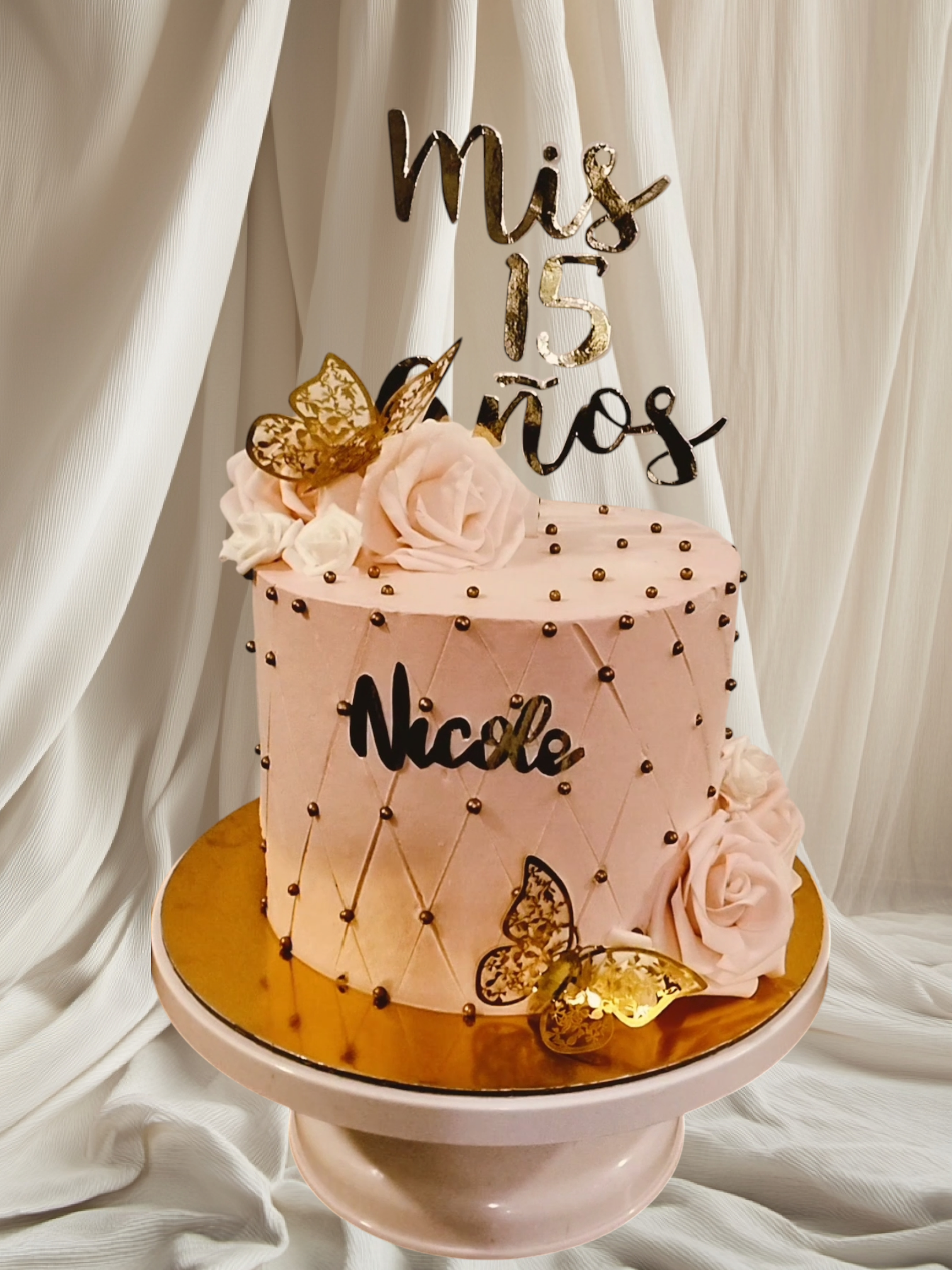 Un pastel con el nombre Nicole está sobre un soporte para pasteles.