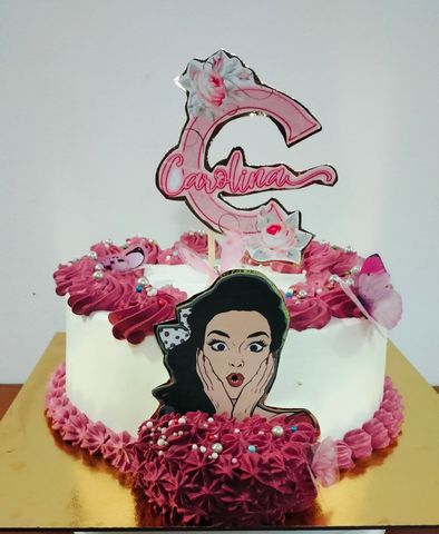 Un pastel con la imagen de una mujer y la letra c encima.