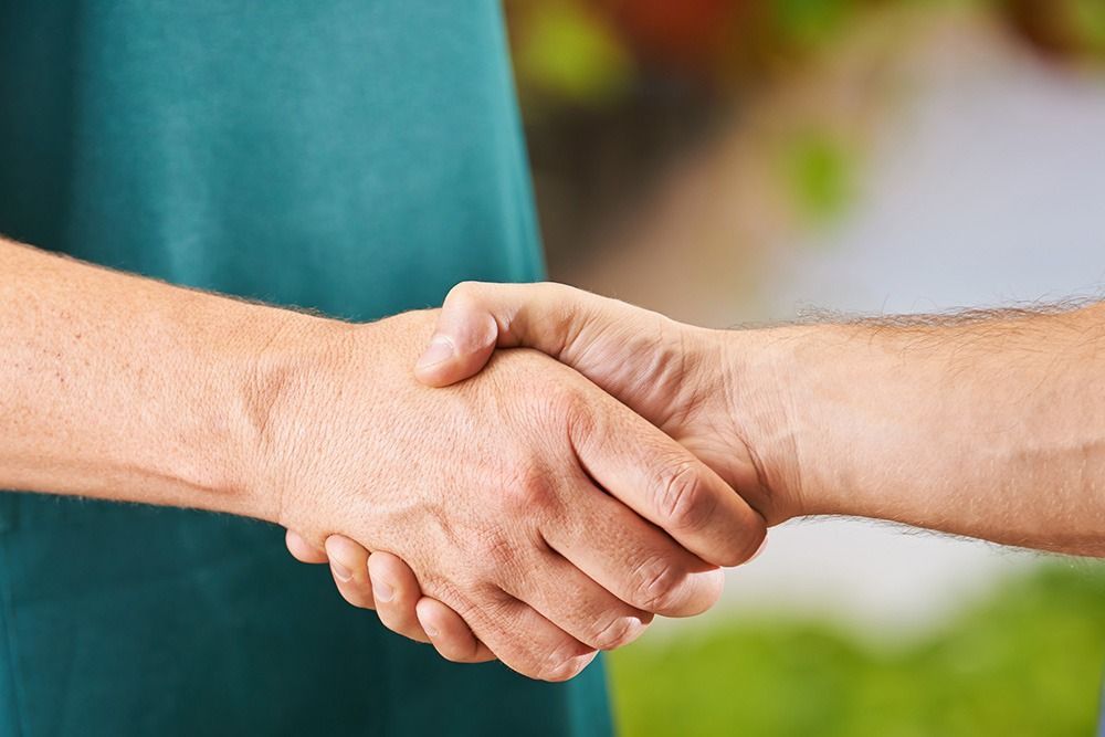 Eine Nahaufnahme von zwei Menschen, die sich die Hände schütteln.