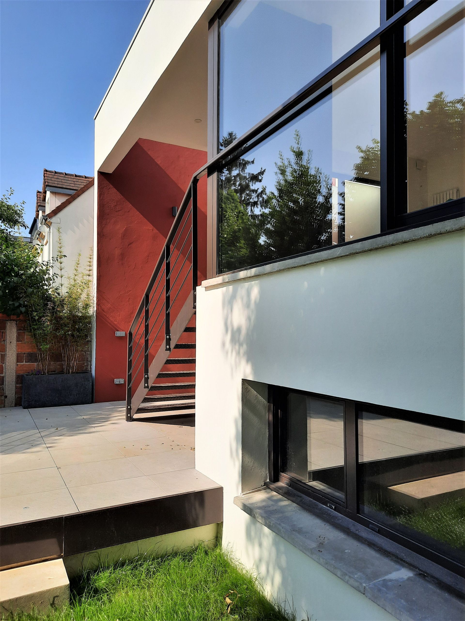 Maison blanche, rouge et pierre avec escalier