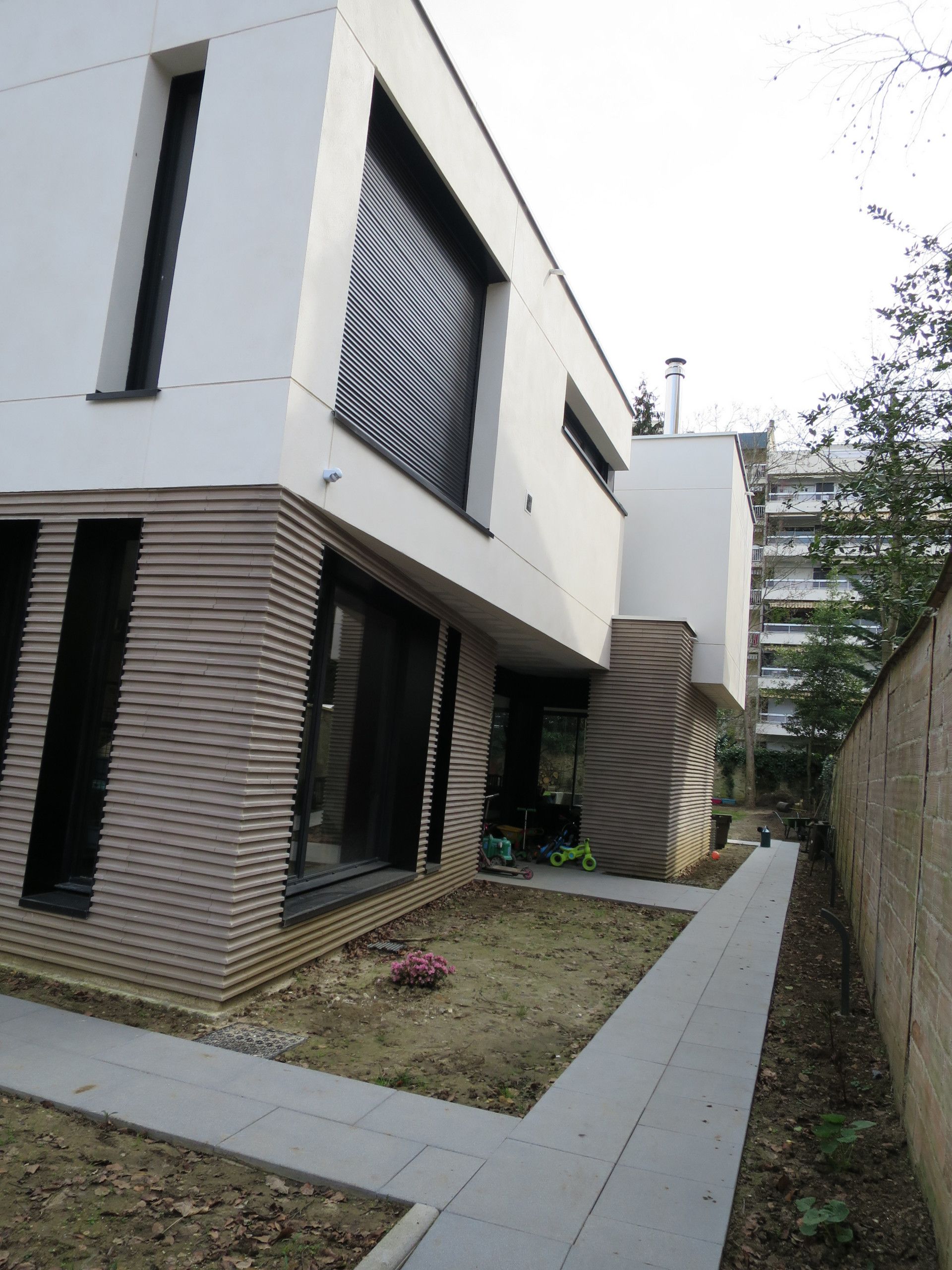 Maison blanche avec des briques et menuiseries blanches