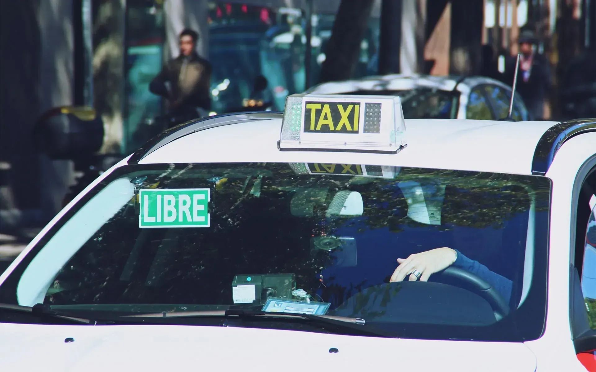 Un taxi blanco con un letrero luminoso que decía 