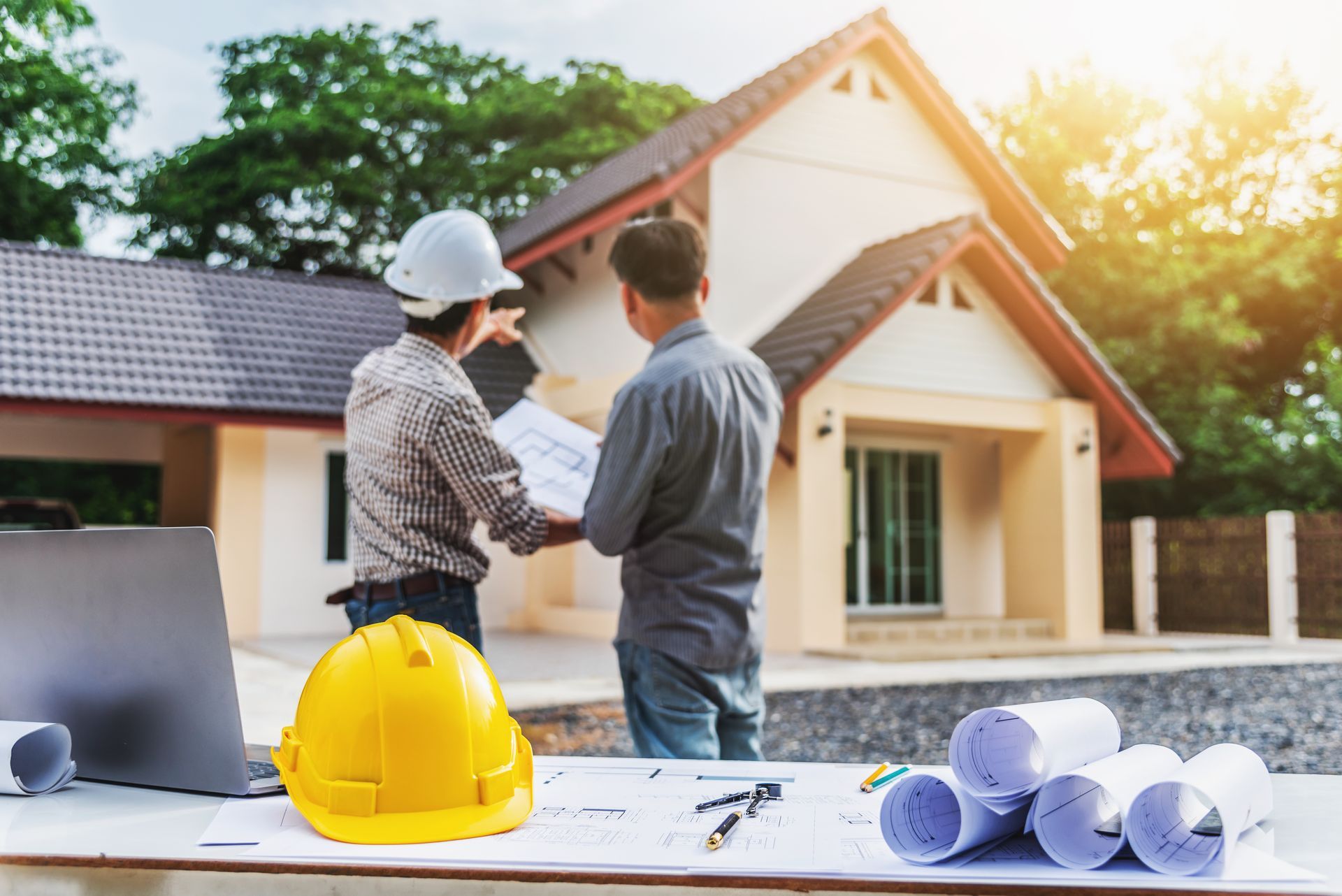 Deux hommes de dos face à une maison en construction