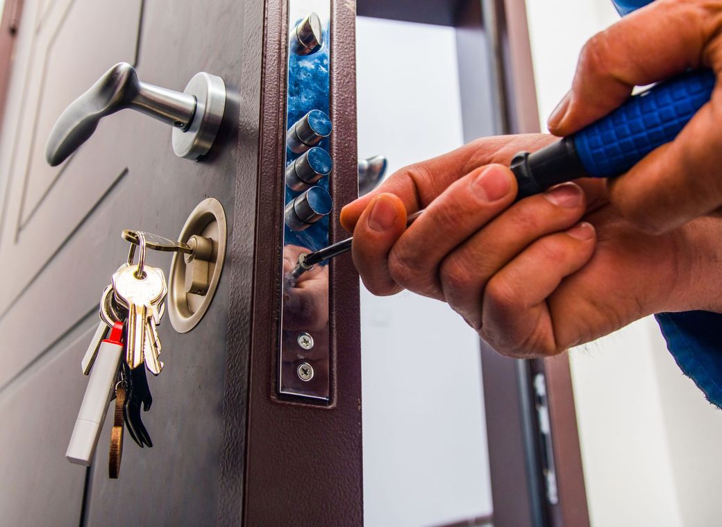 Homme qui installe un mécanisme de fermeture de porte