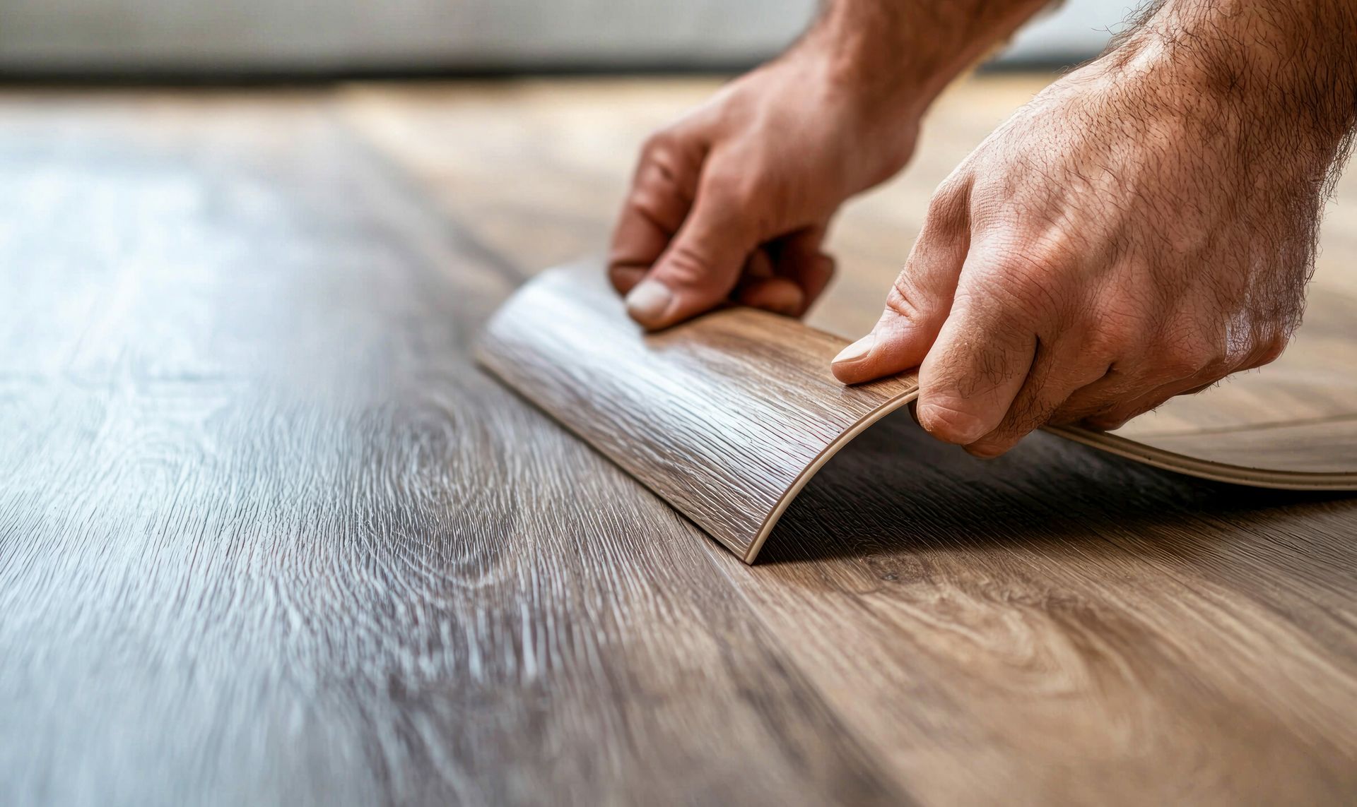 Mains tenant des lames vinyles effet parquet