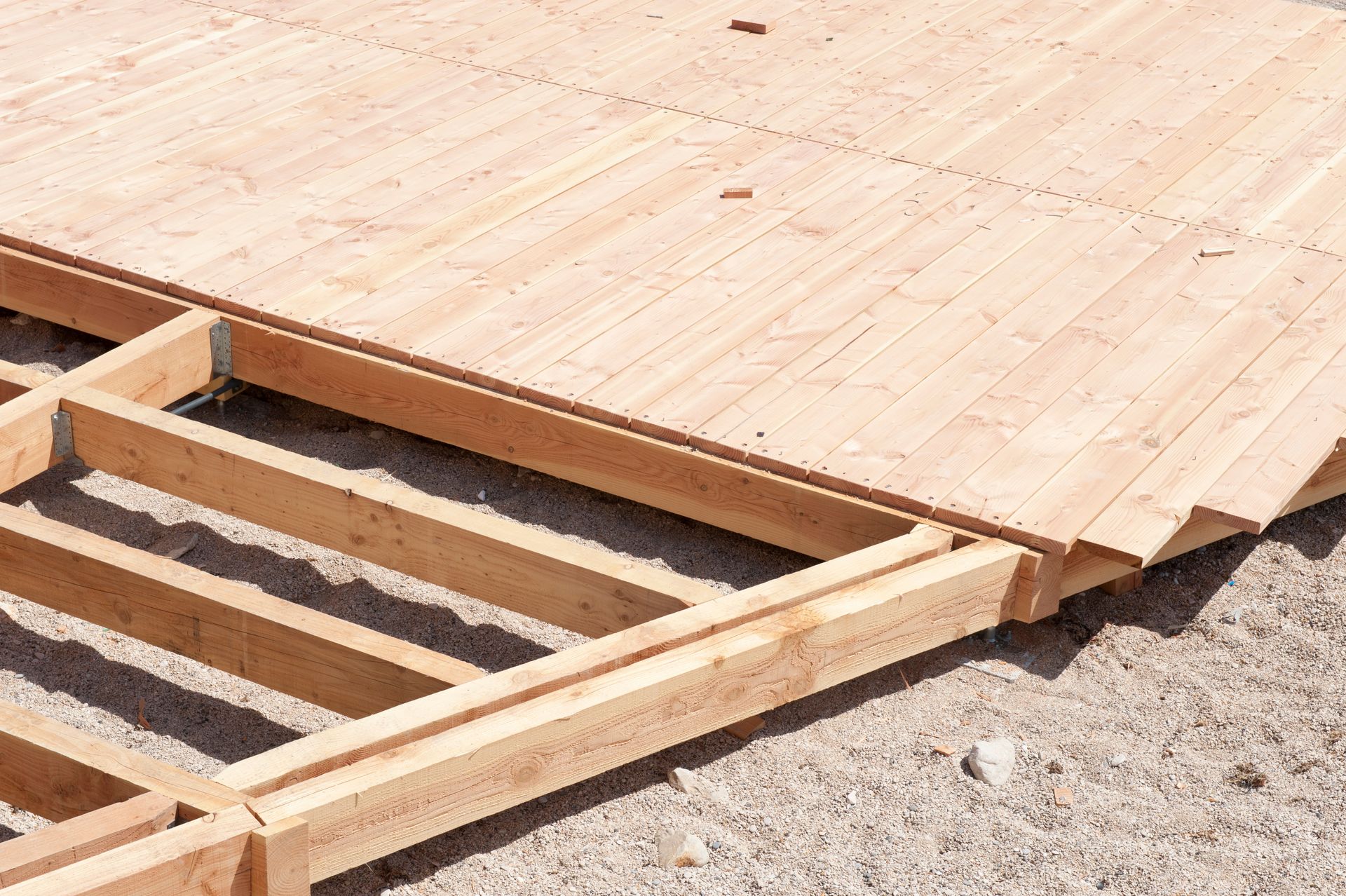 Terrasse en bois en cours de construction sur du sable