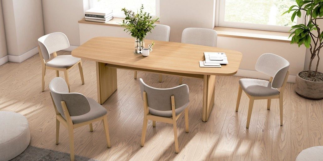 Mesa de comedor de madera con seis sillas, flores y un gran ventanal.