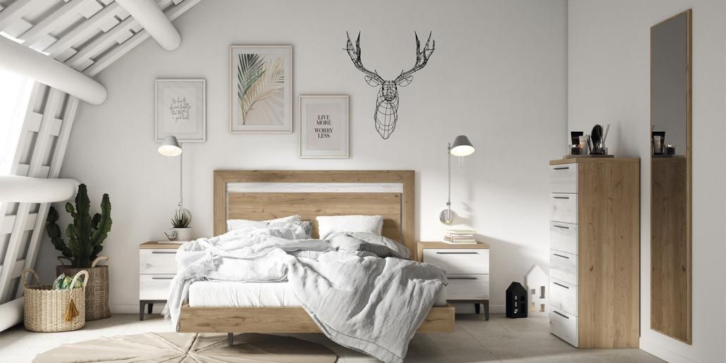 Dormitorio con cama, obras de arte y un diseño de cabeza de ciervo en la pared. Tiene paredes blancas y muebles de madera.