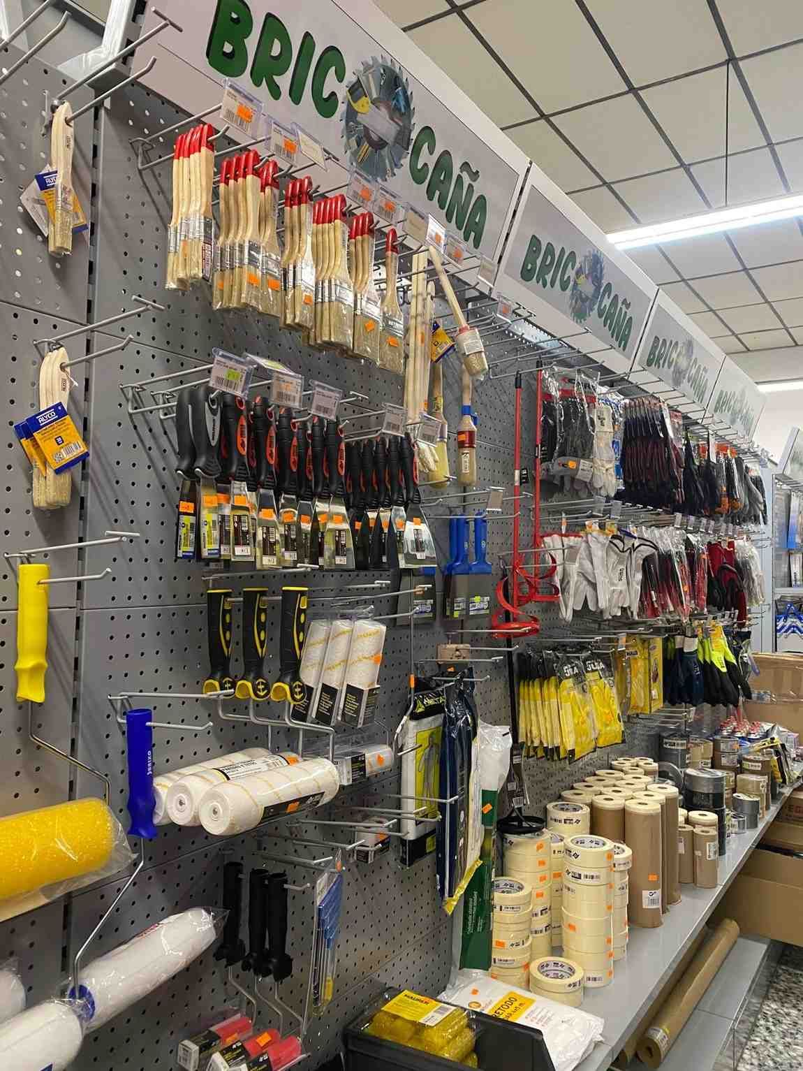 Exhibición de ferretería con pinceles, rodillos y otros suministros de pintura.