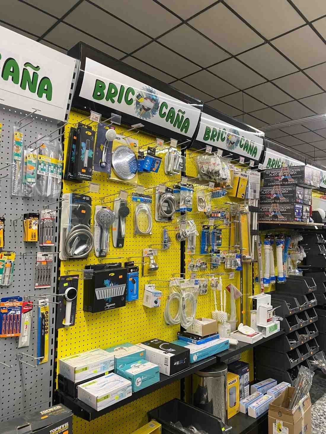 Un empleado de una tienda ayuda a un cliente en el pasillo de una ferretería, señalando un producto en el estante.